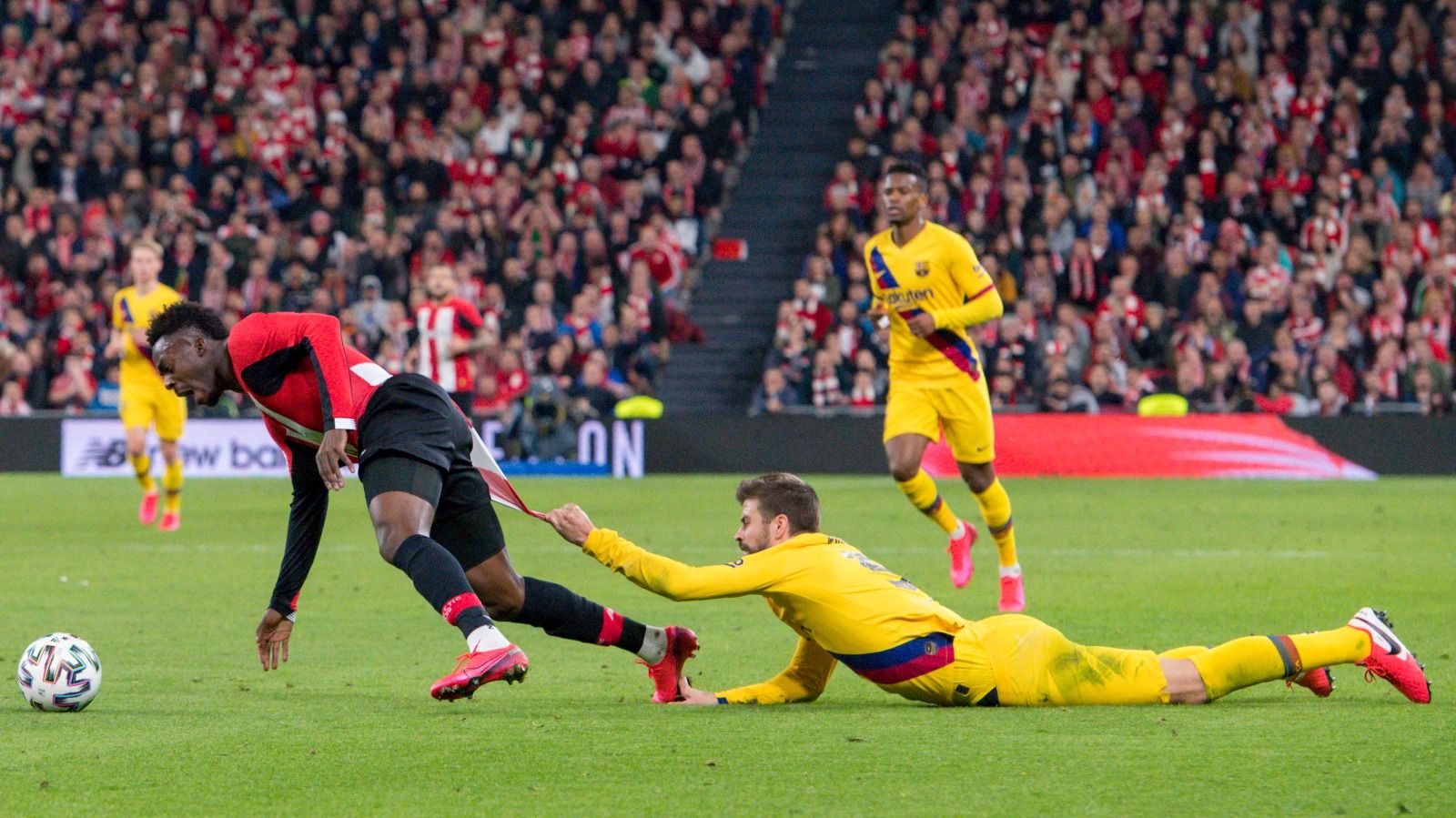 Iñaki Williams se lleva arrastrando a Piqué agarrado de su camiseta.