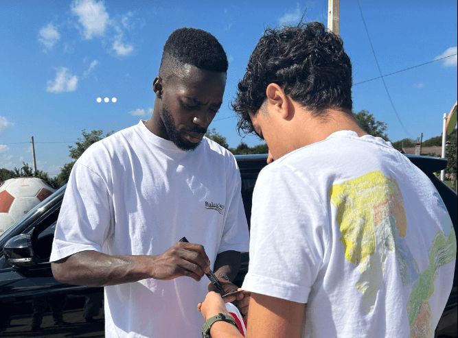 Iñaki Williams firmándoles antes de subirles al coche