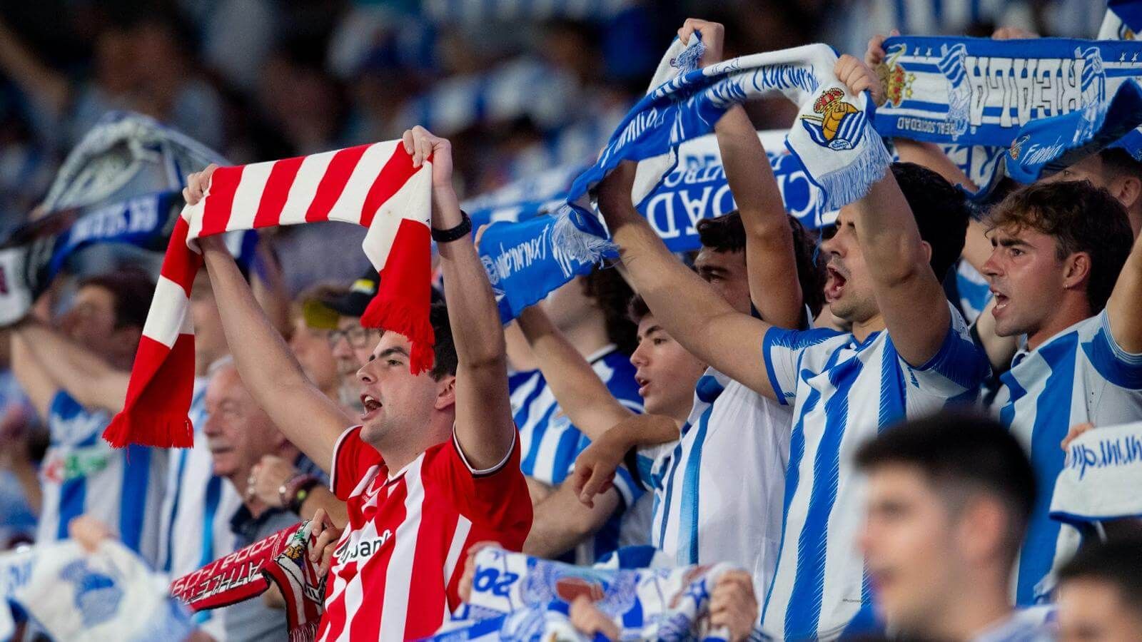 Las dos aficiones comparten grada con sus bufandas en el derbi vasco de Anoeta, el estadio de la Real Sociedad.