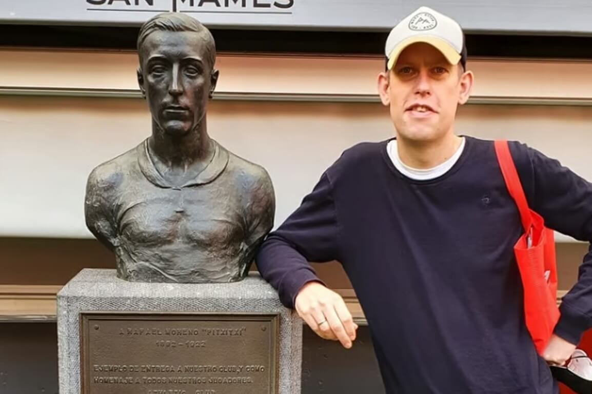  El escritor germano Dirk Segbers posa en 2022 en San Mamés, el campo del Athletic Club, junto al busto de 'Pitxitxi'.