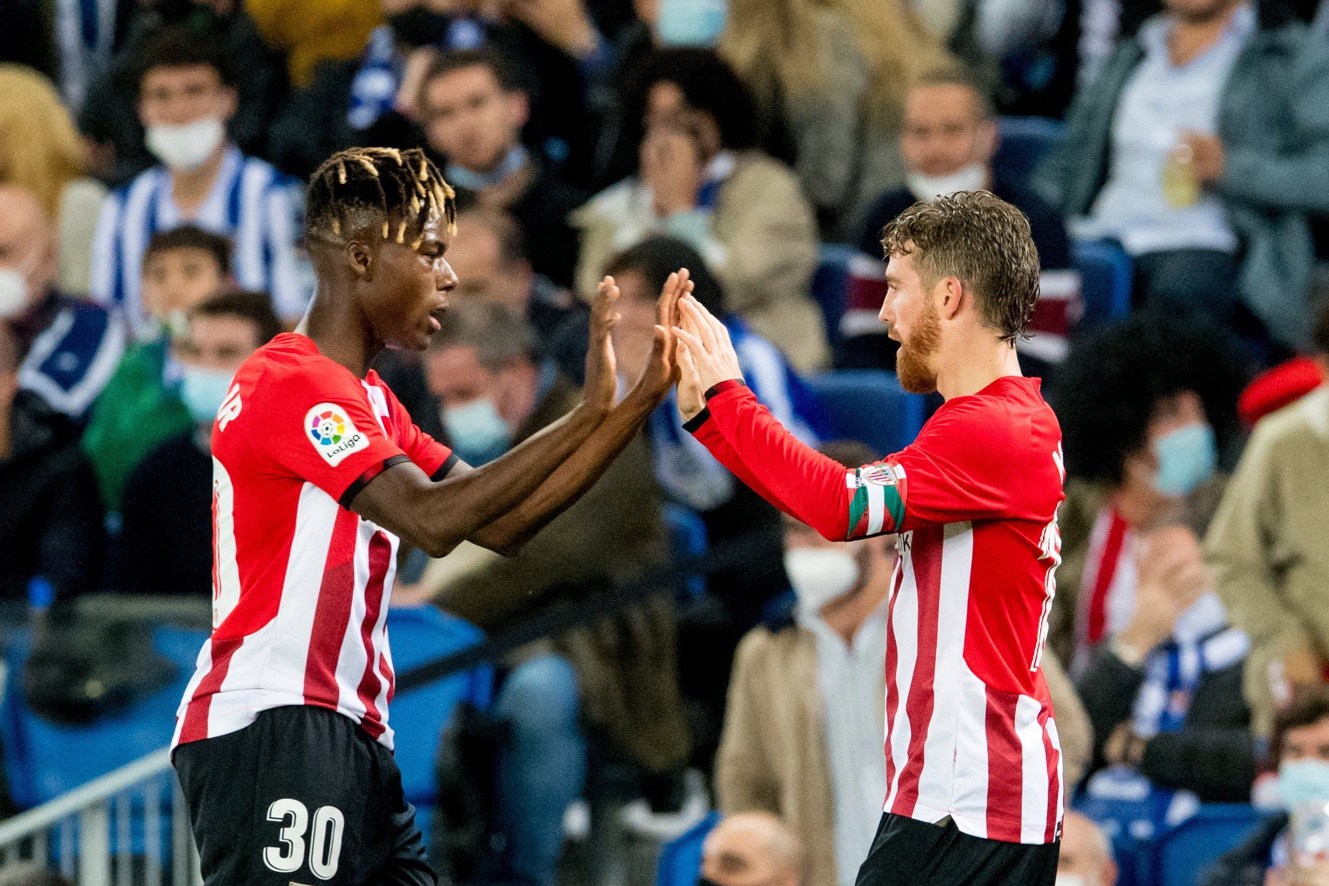 Nico Williams choca las manos con Iker Muniain en el derbi de Anoeta.
