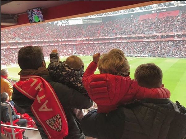 Seguidores del Athletic Club animan, con niños en sus brazos, en la grada de San Mamés.