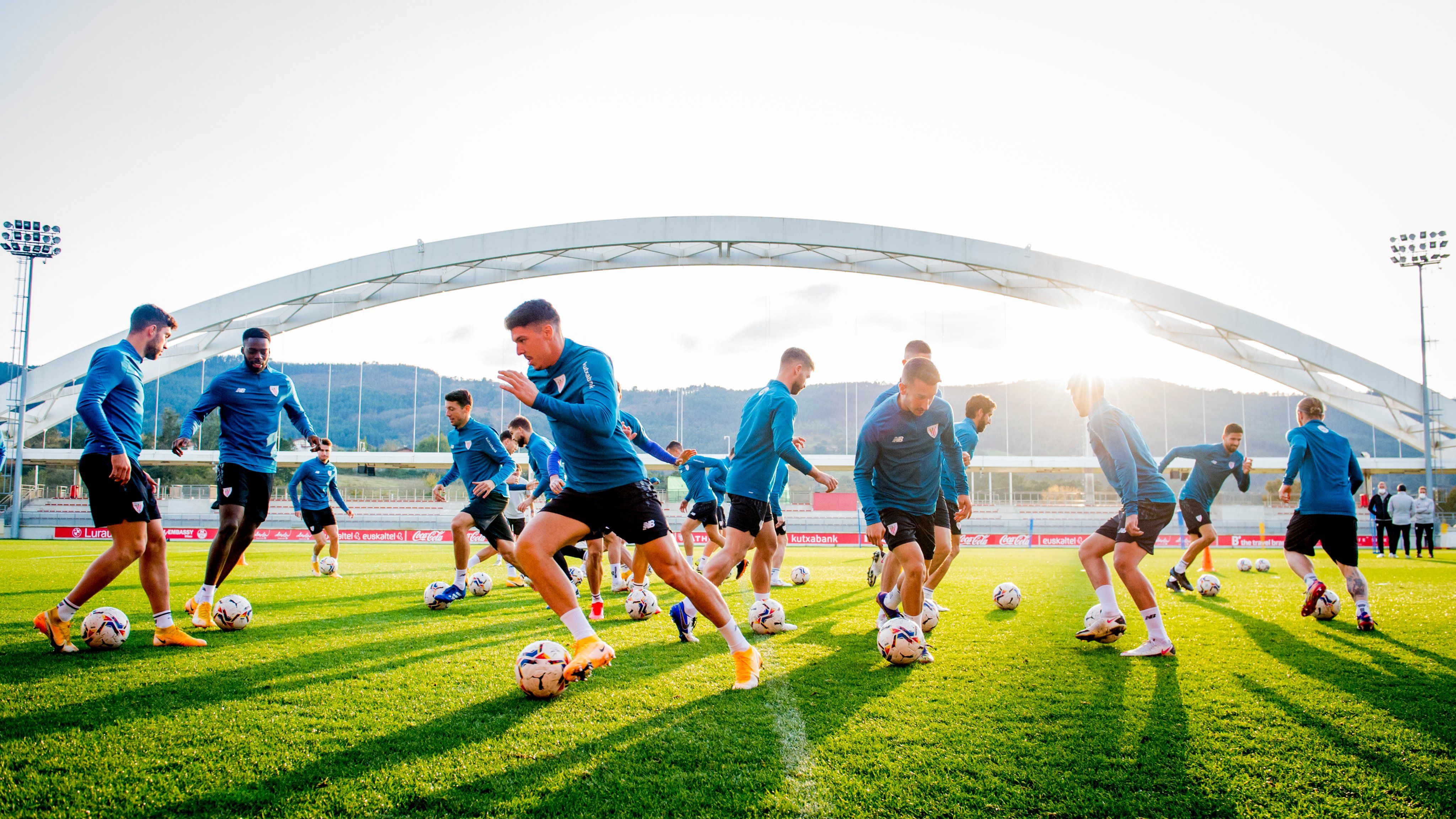  Los jugadores rojblancos trabajan bajo el sol y el arco de Lezama.