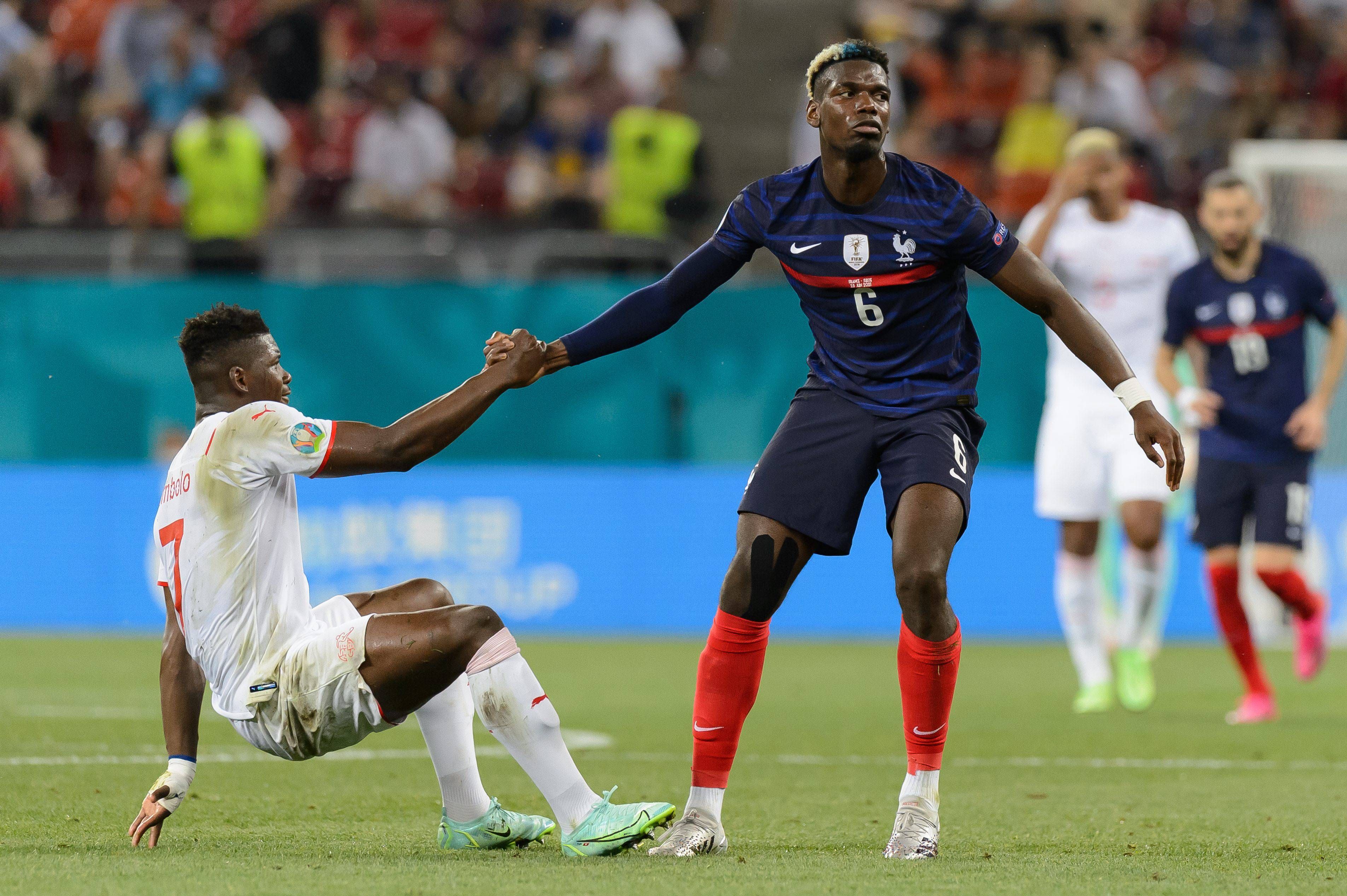  Paul Pogba ayuda a levantarse a Embolo en el Francia-Suiza.