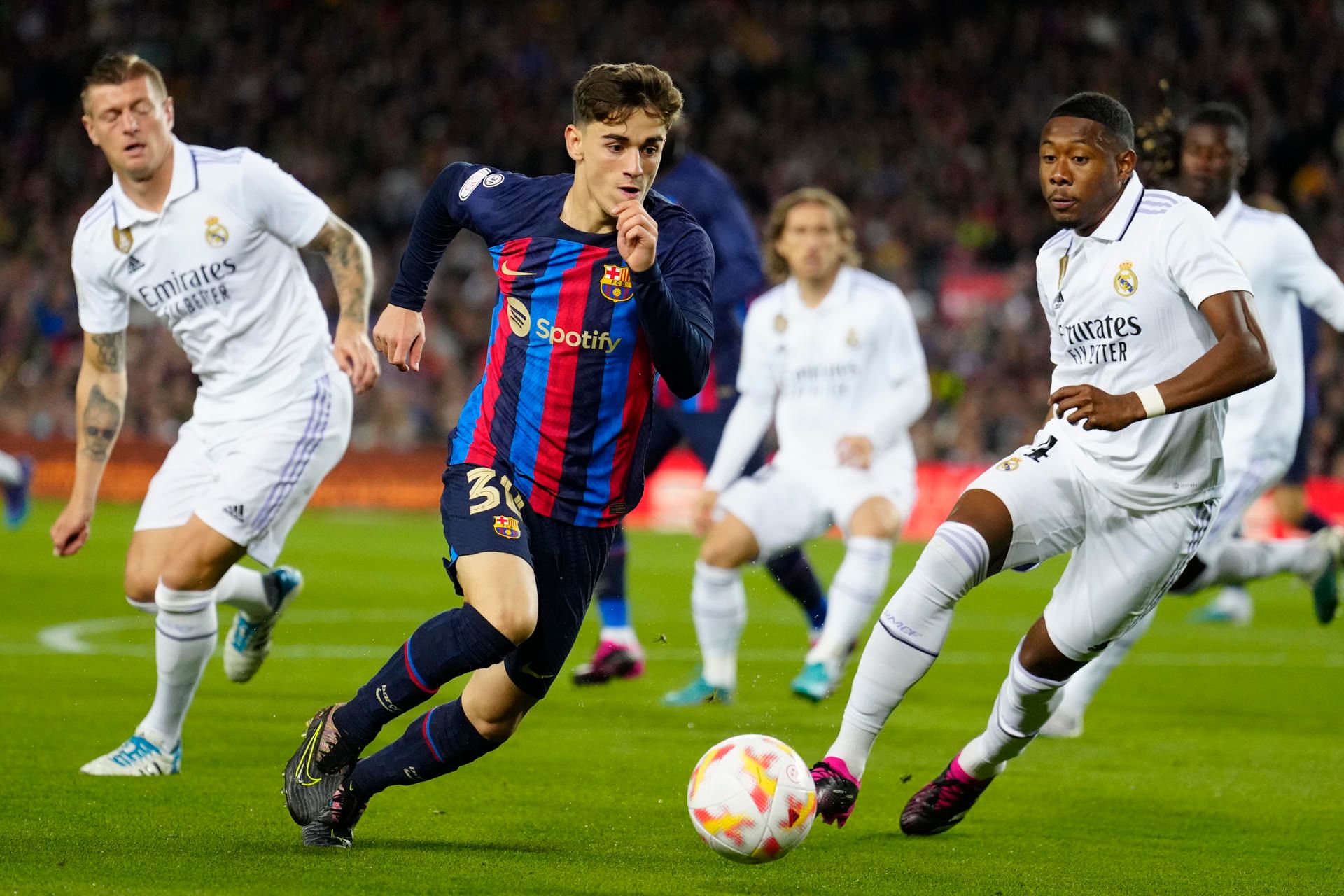 Gavi se marcha con el balón ante la presión del Real Madrid.