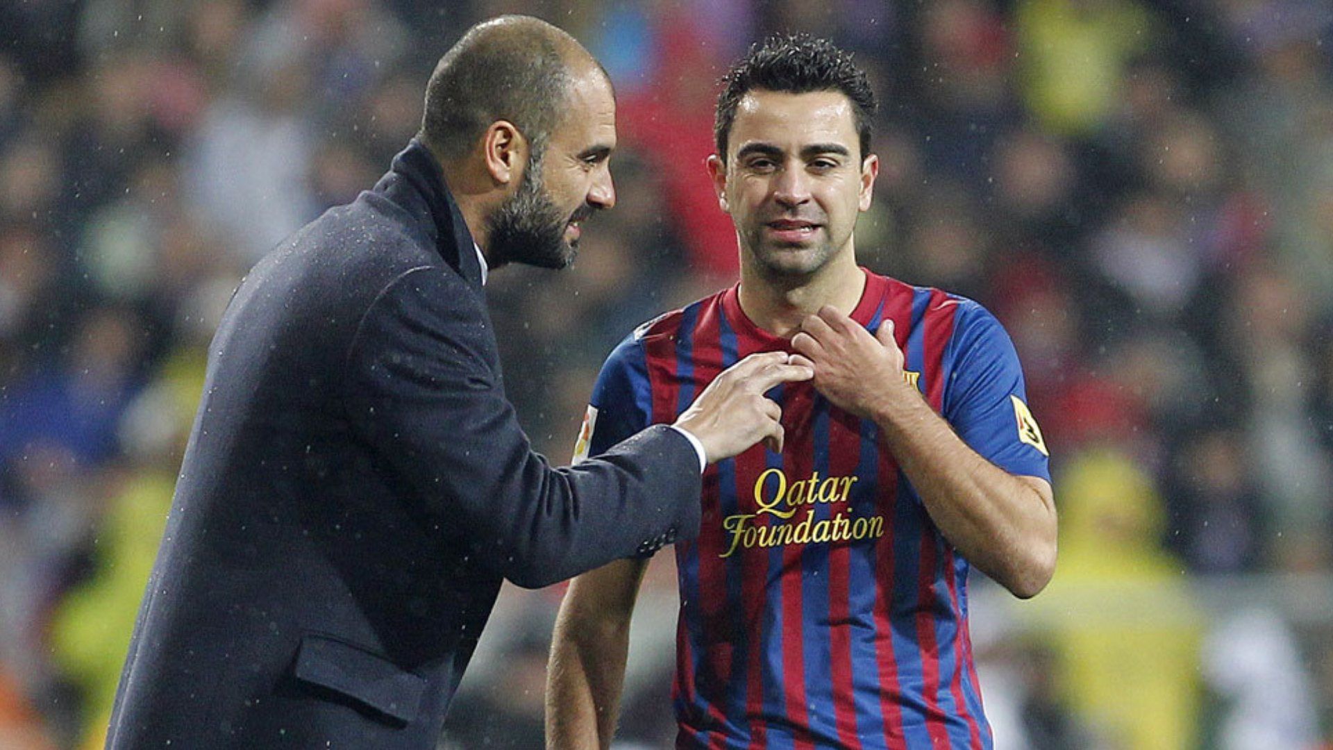 Pep Guardiola da instrucciones a Xavi Hernández durante un partido.