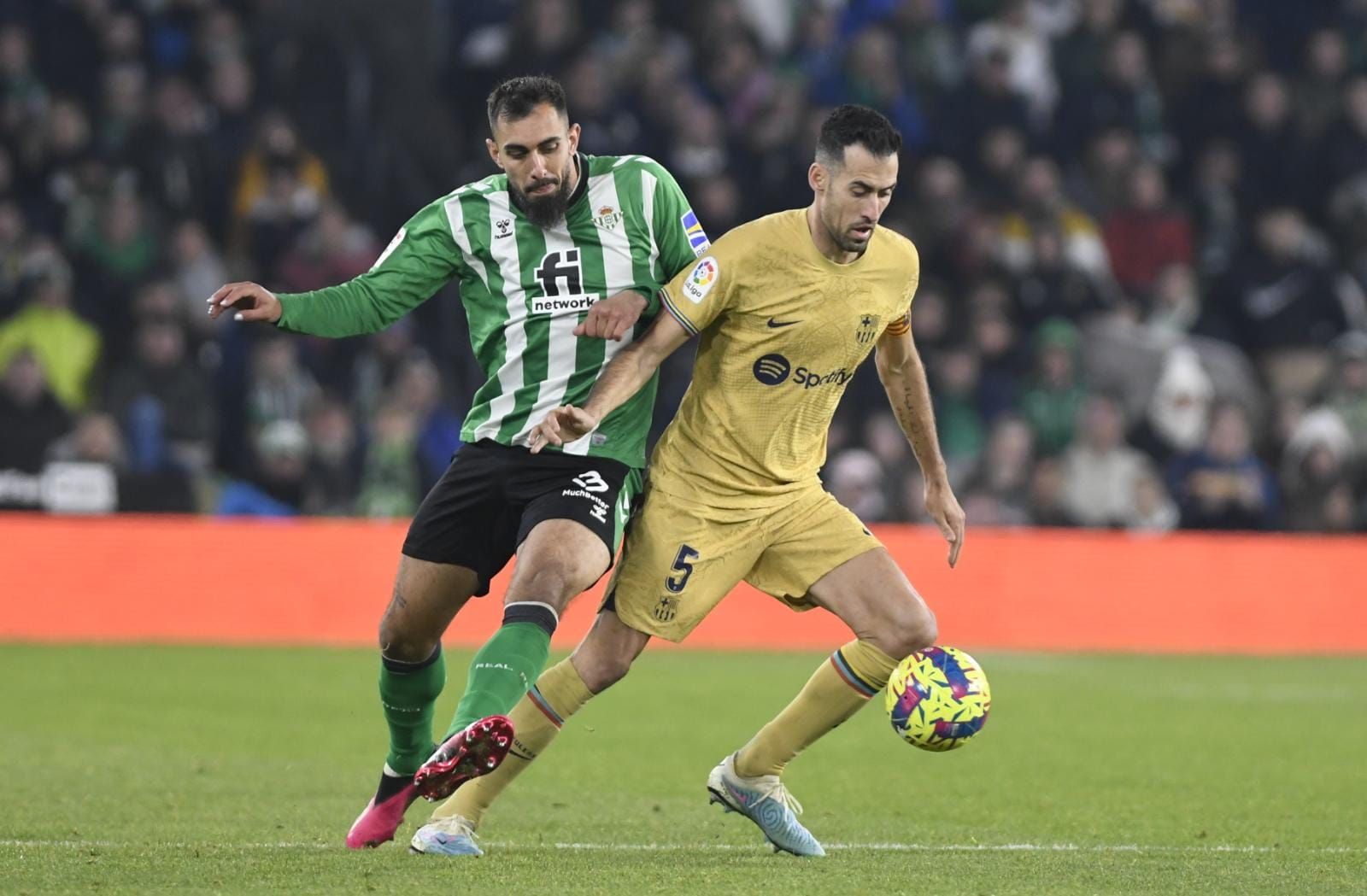 Sergio Busquets protege un balón ante Borja Iglesias en el Betis-Barcelona.