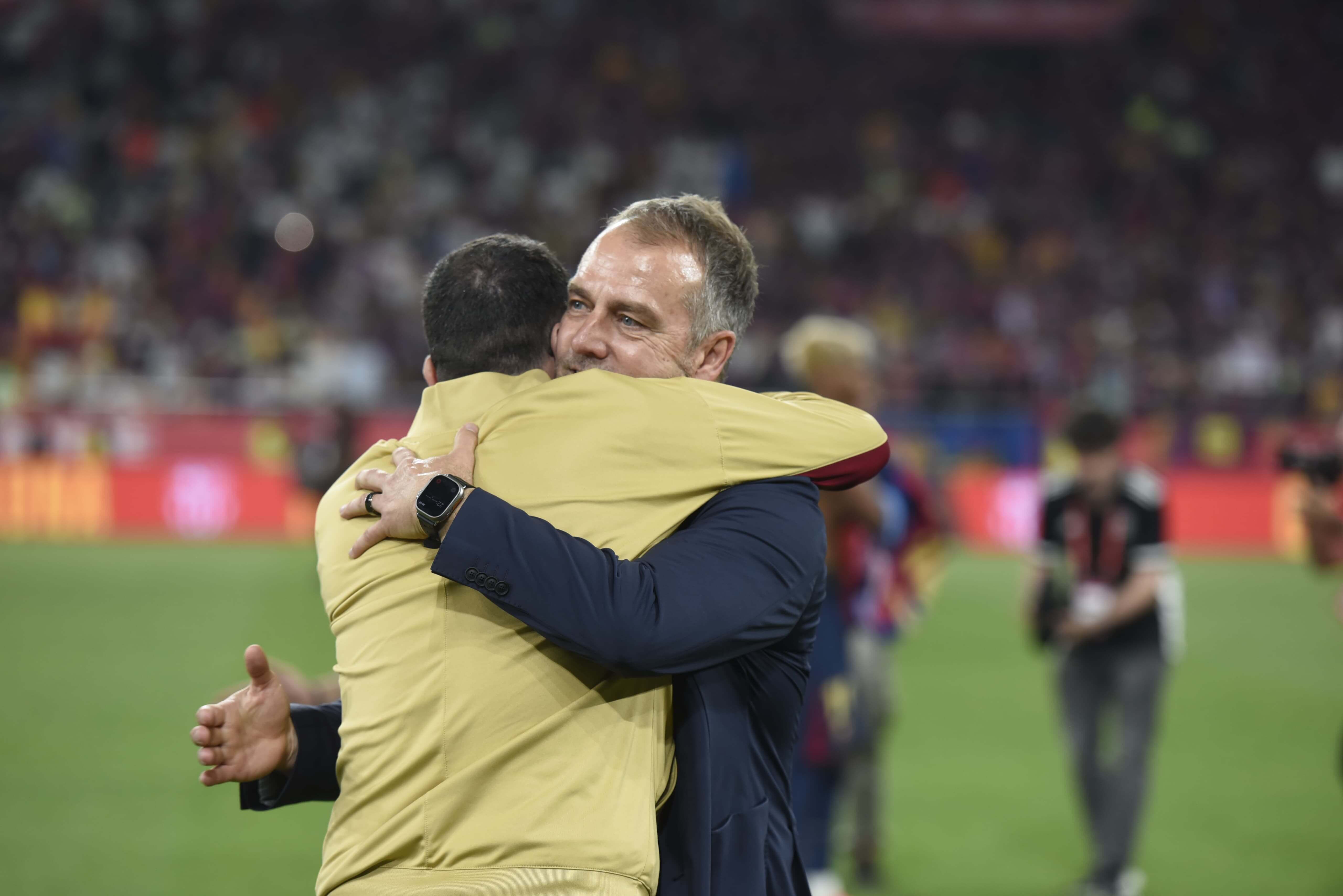 Hansi Flick se abraza con un miembro del cuerpo técnico