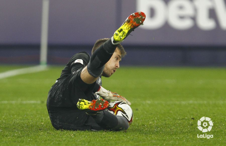  Aitor Fernández atrapa en el césped un balón.