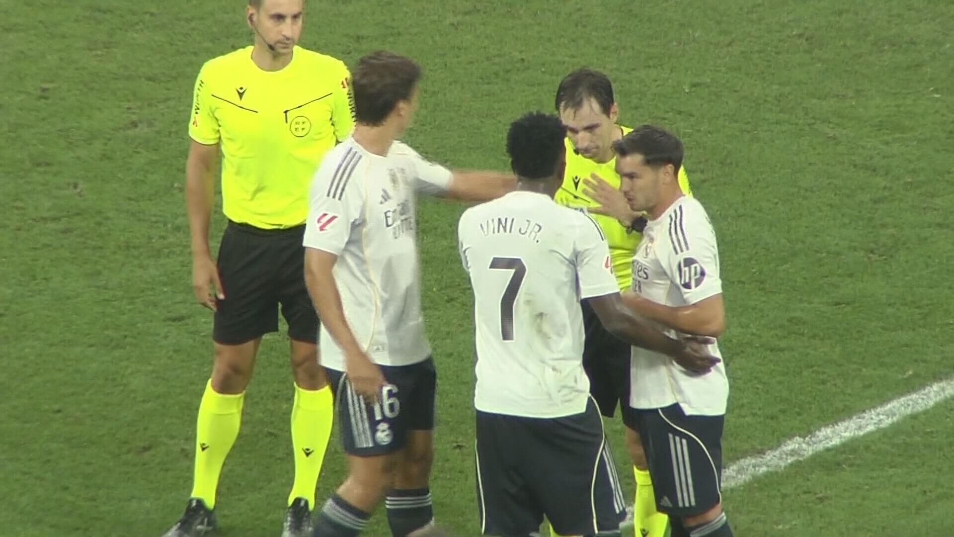 Vinicius y De Burgos hablando después del Oviedo-Real Madrid