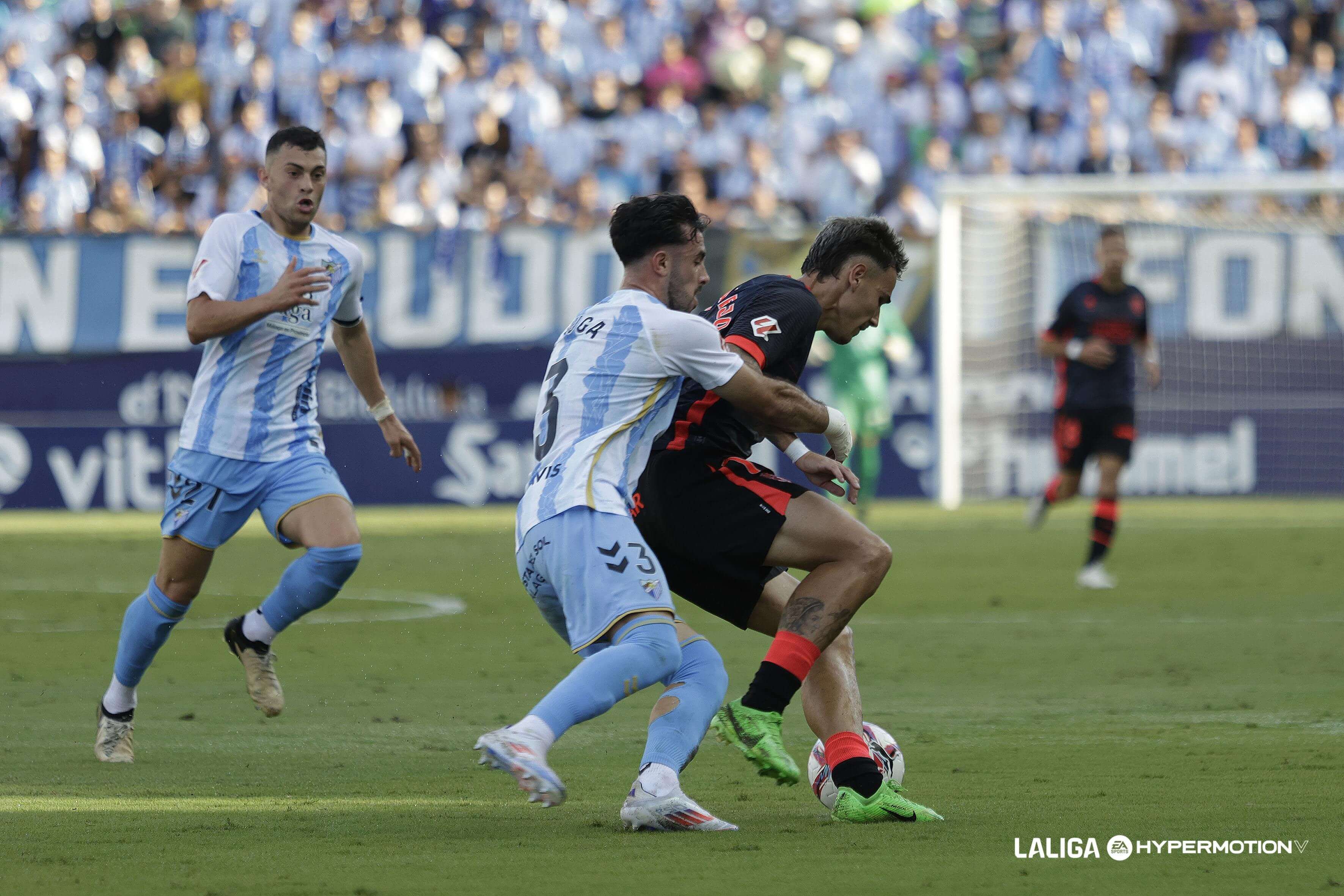 Carlos Puga presiona a Hugo Vallejo en el Málaga - Huesca.