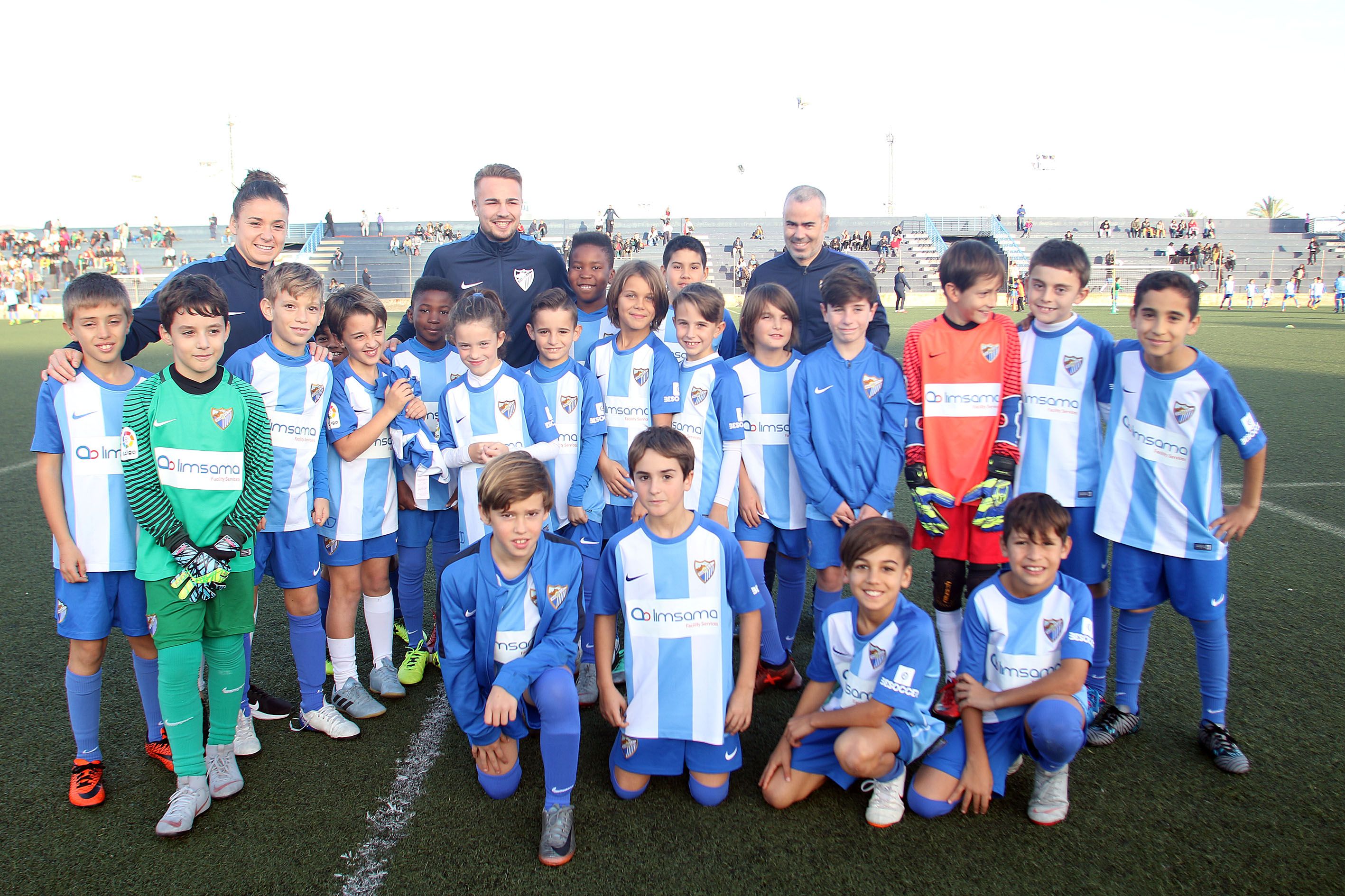 Chelsea y Ontiveros posan con un equipo del fútbol base.