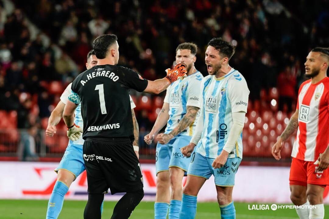 Los jugadores del Málaga celebran el penalti fallado por Luis Suárez.