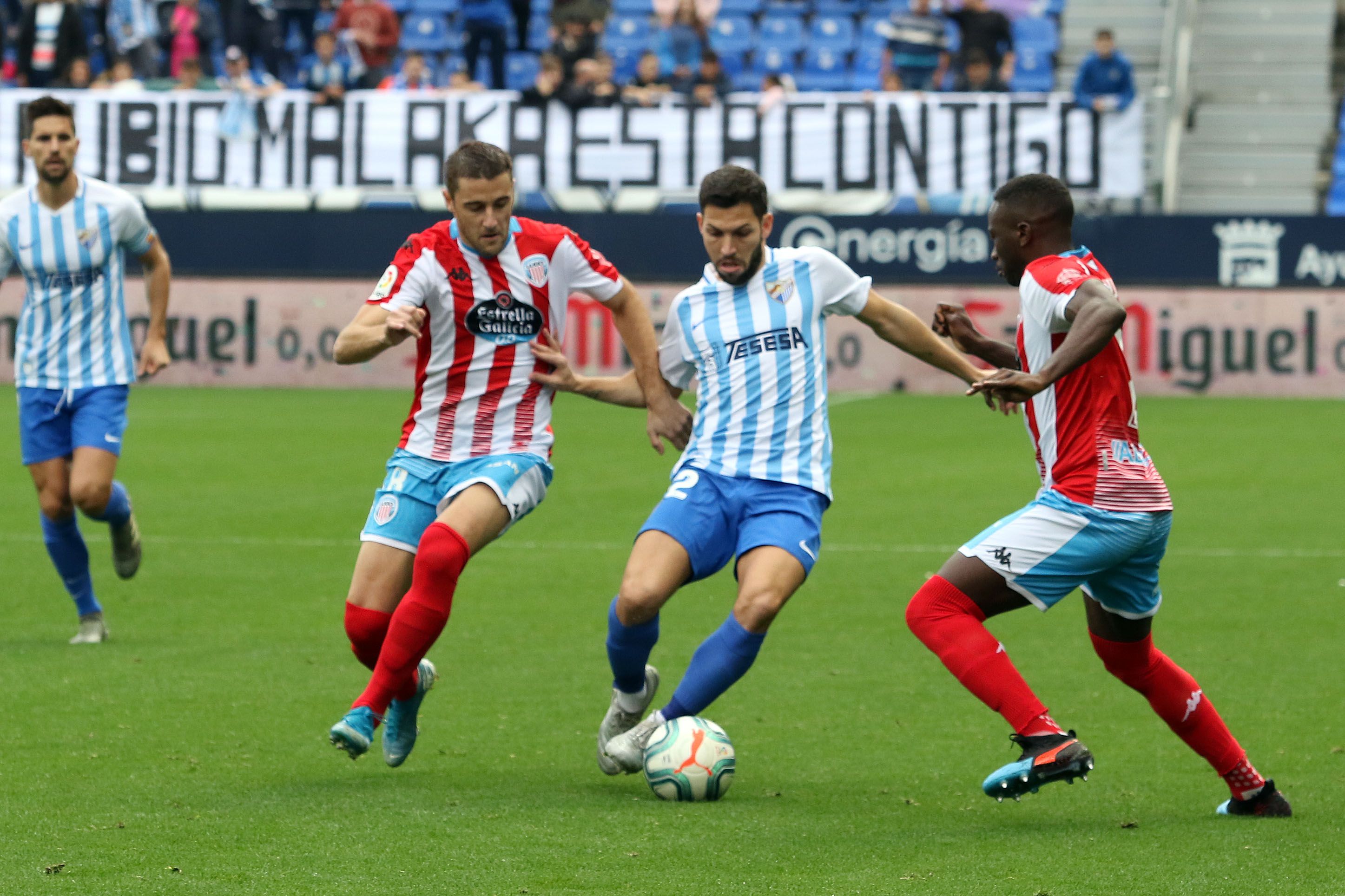Pacheco intenta driblar a dos defensas del Lugo.