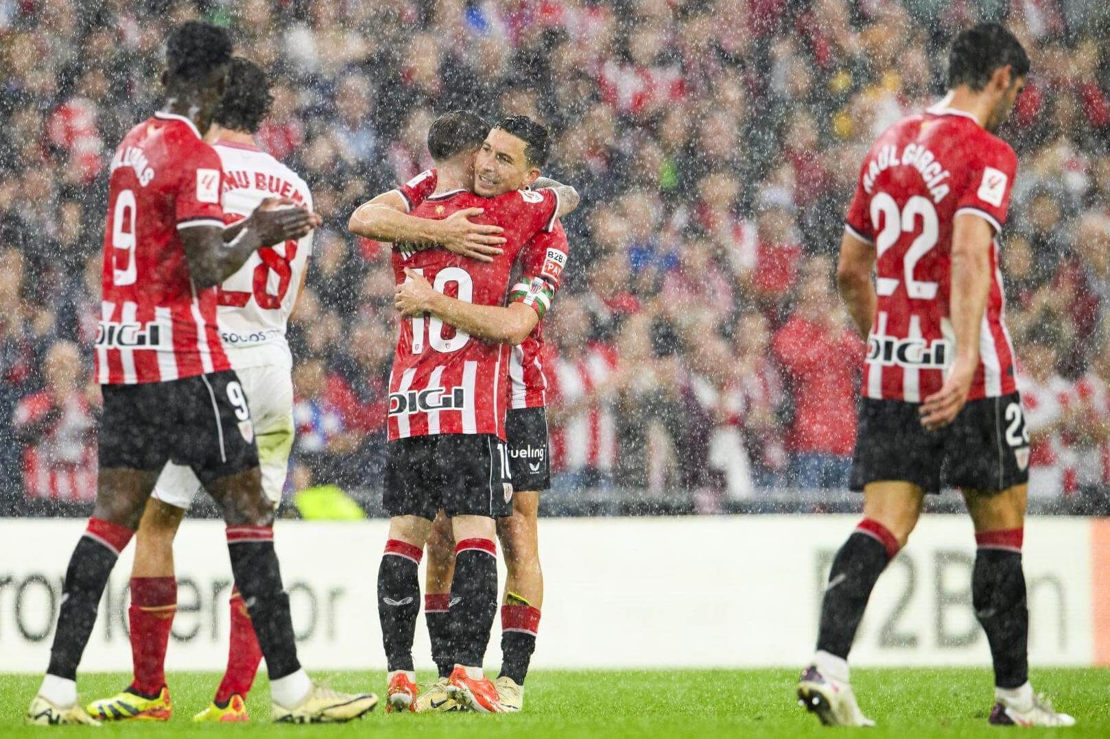  Abrazo de Iker Muniain a Oscar De Marcos, bajo el diluvio en el partido ante el Sevilla en San Mamés.