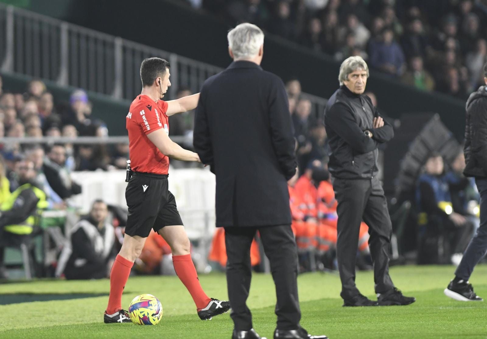  Pellegrini, con Ancelotti de espaldas, en el césped del Villamarín durante el partido.