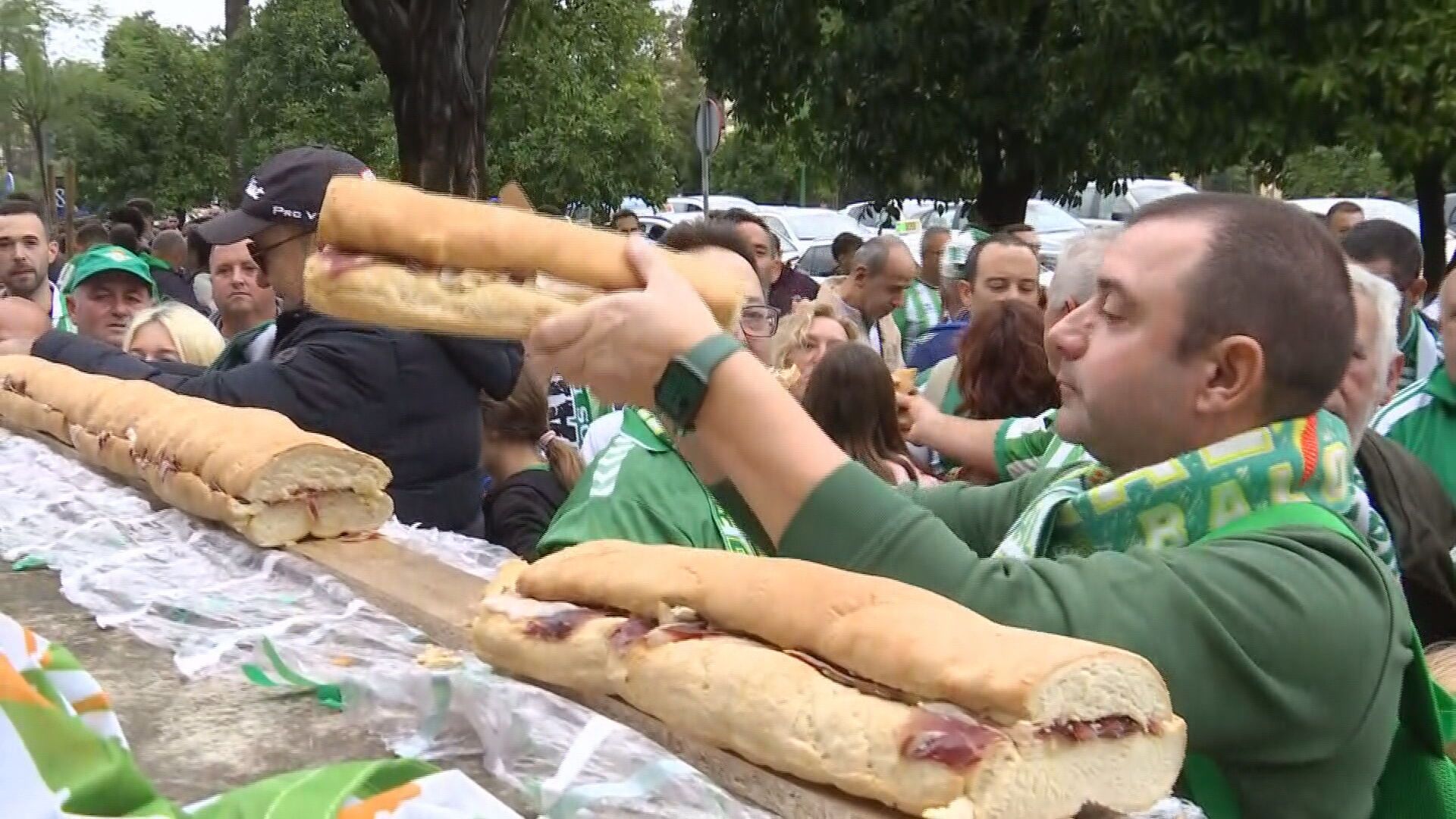La peña bética reparte el bocadillo antes del Real Betis - Mallorca de este sábado.