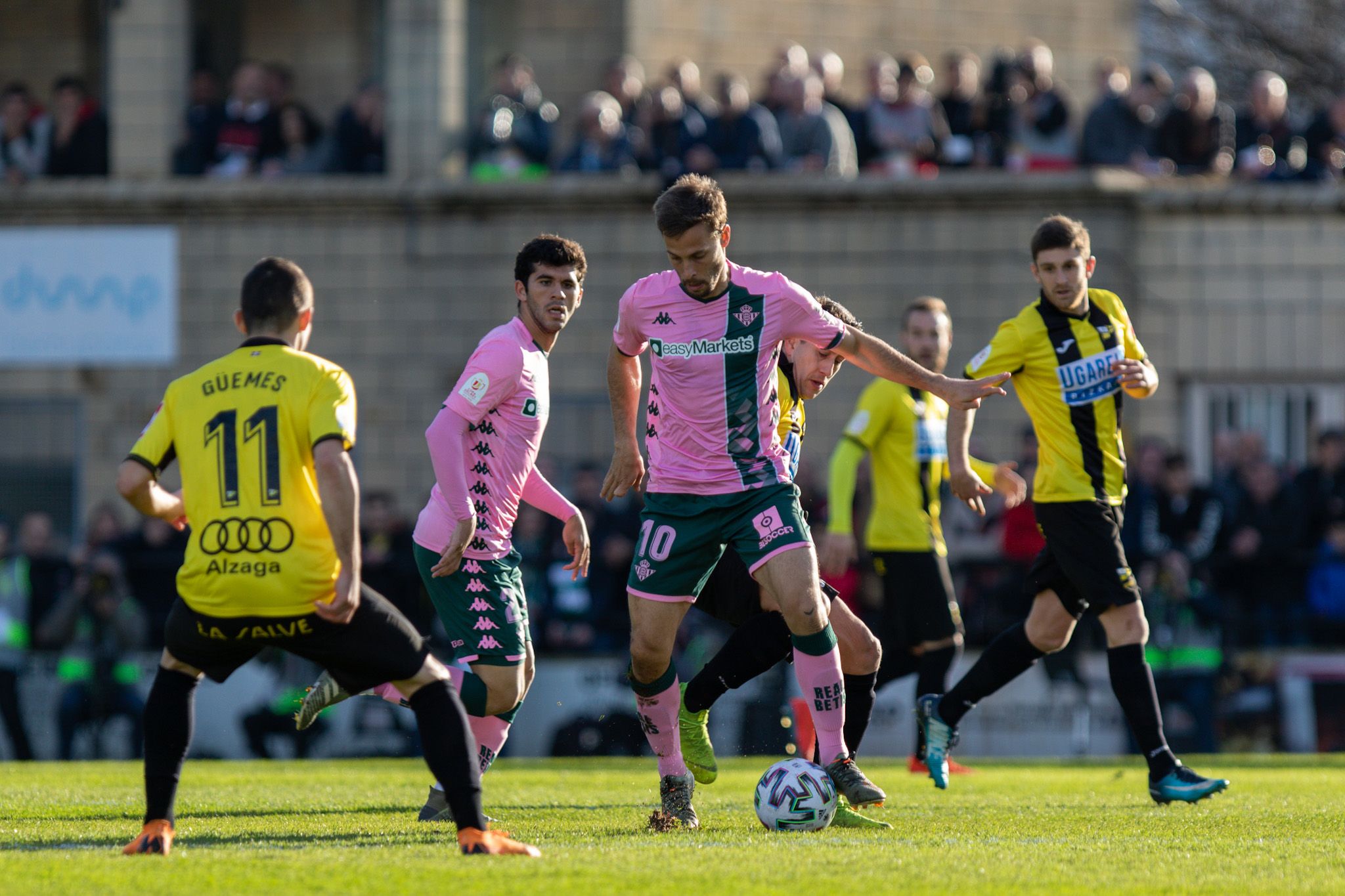  Sergio Canales controla un balón vigilado por Güemes.