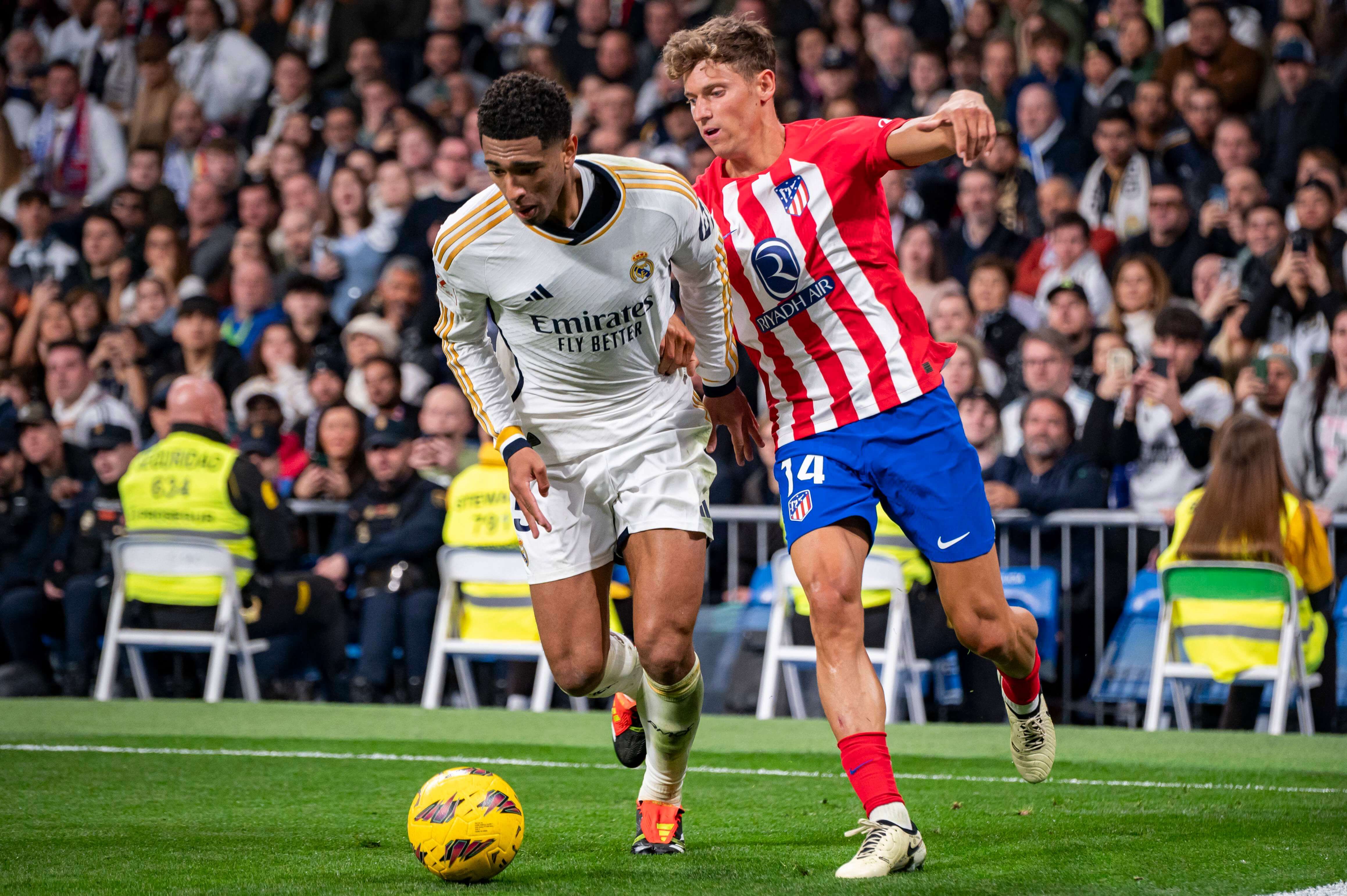  Jude Bellingham disputando un balón con Marcos Llorente.