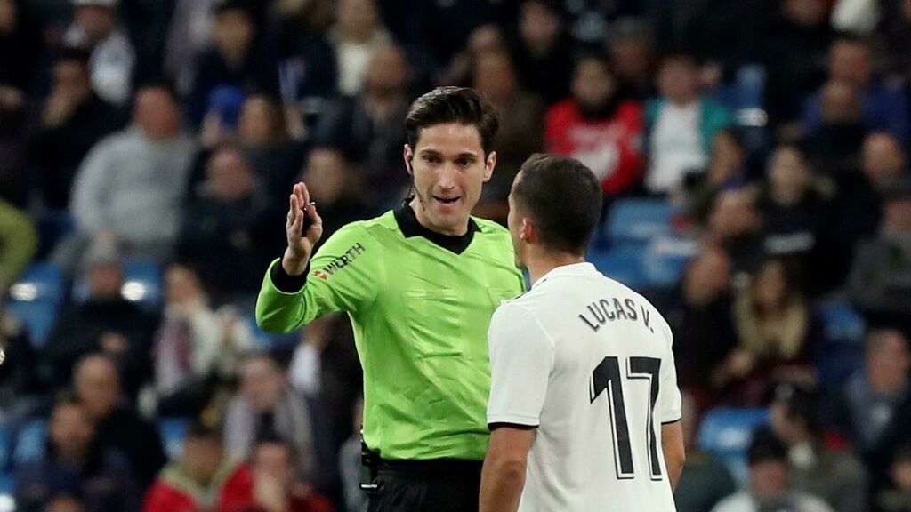  El colegiado Munuera Montero habla con Lucas Vázquez, jugador del Real Madrid.