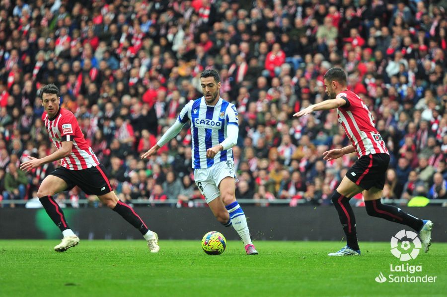 Mikel Merino conduce en el derbi ante dos jugadores del Athletic.