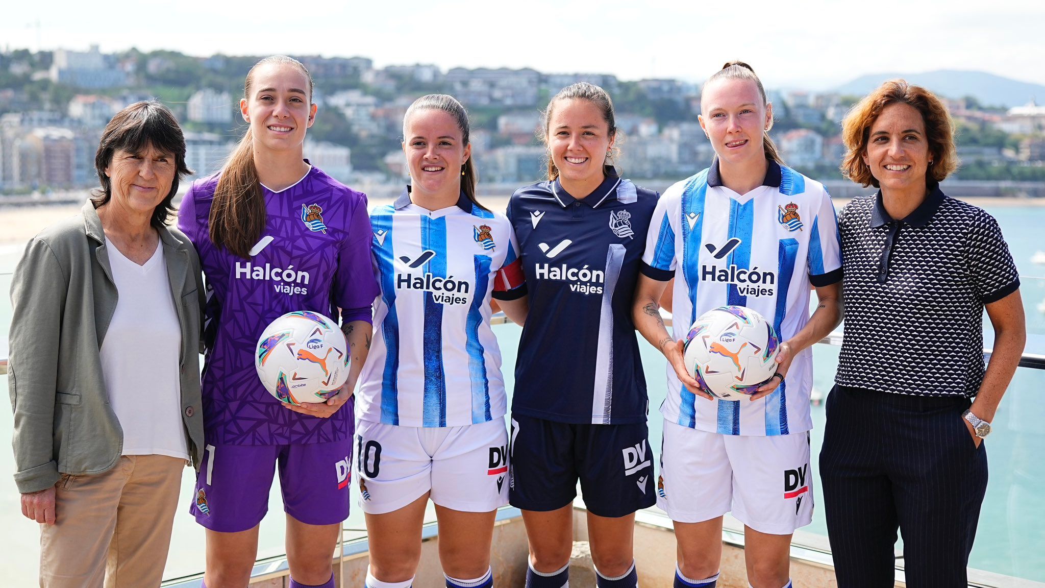 Jugadoras de la Real, entrenadora y directora deportiva, con la camiseta del nuevo patrocinador.