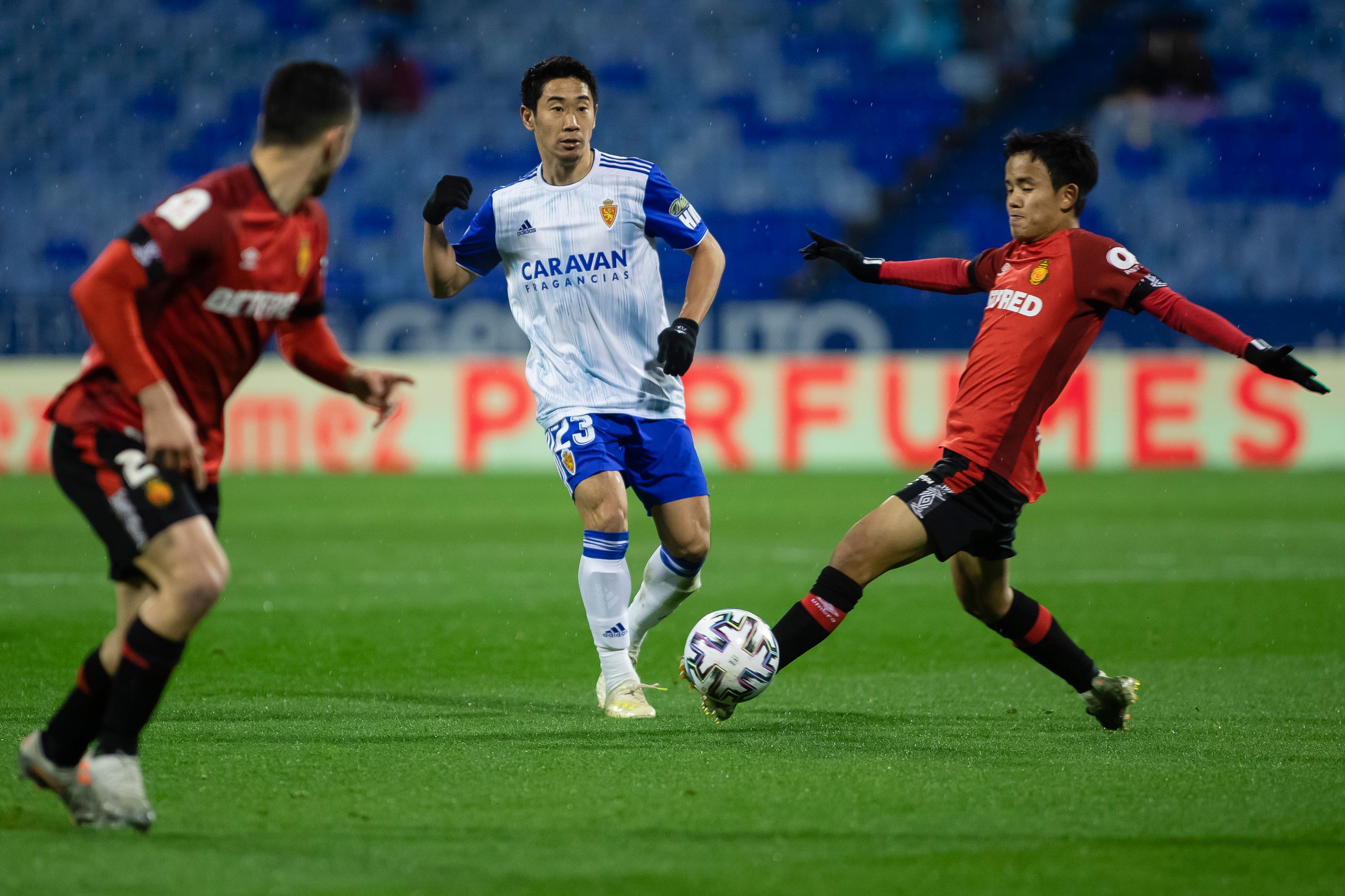  Shinji Kagawa realiza un pase ante la presión de Takefusa Kubo.