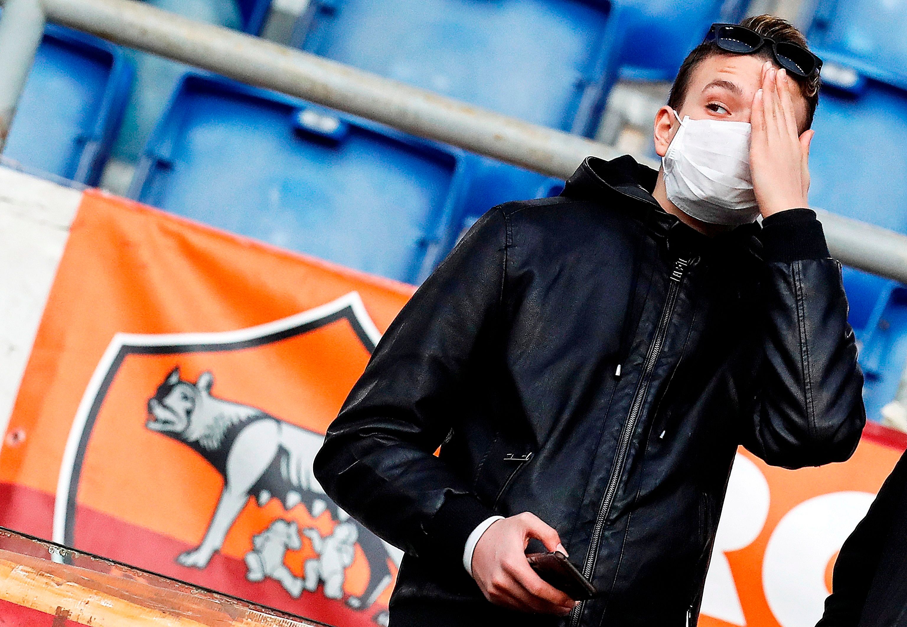  Un aficionado de la Roma con una mascarilla ante la amenaza del coronavirus.