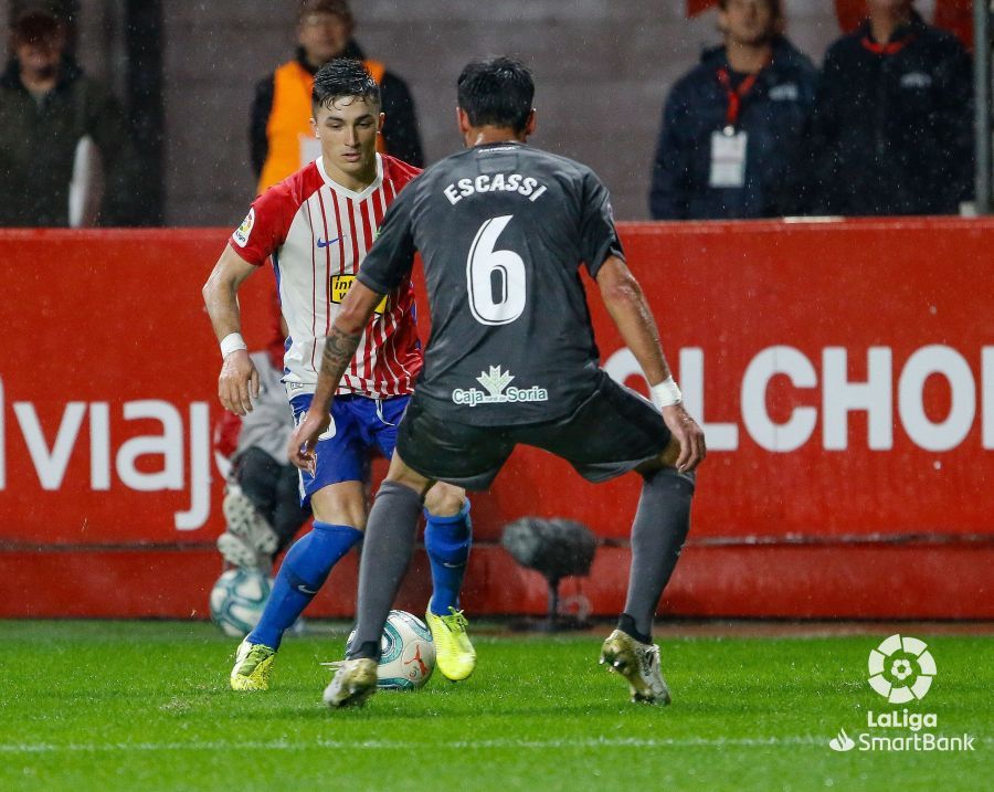 Manu García intenta mantener la posesión del esférico ante la presión del jugador rival.