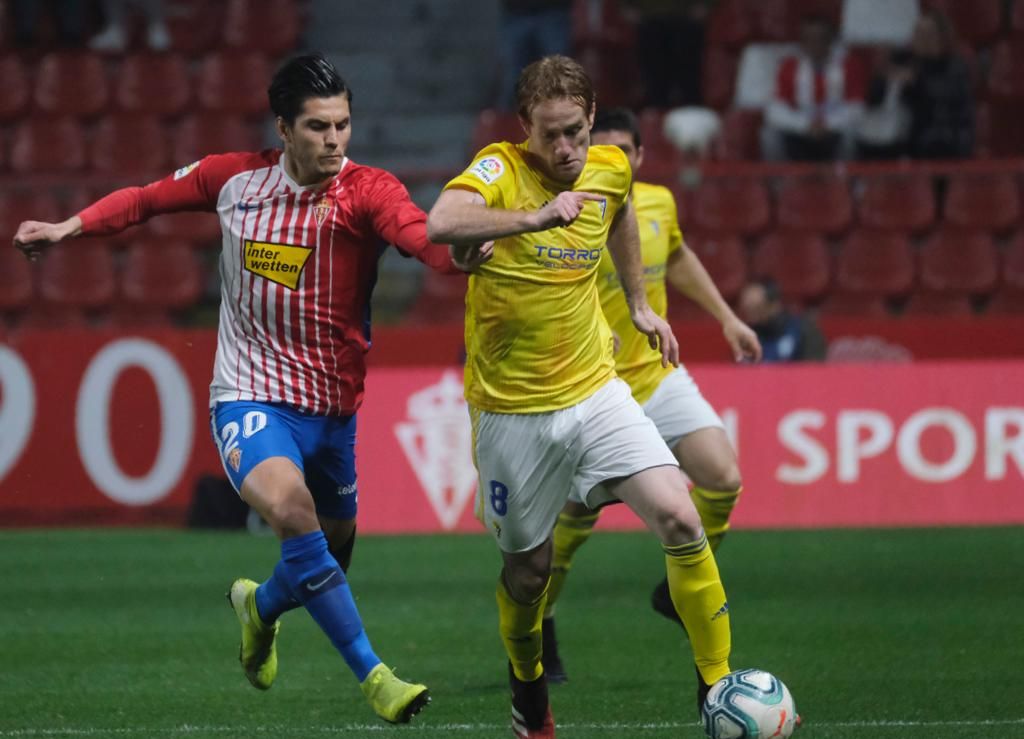 Cristian Salvador y Álex Fernández pugnan por un balón en el Sporting-Cádiz