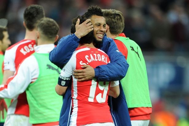  Cazorla y Coquelin se abrazan.