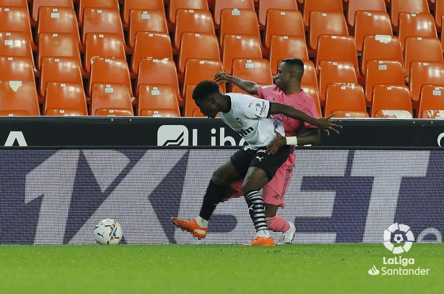 Musah intenta no perder el balón ante Vinícius.