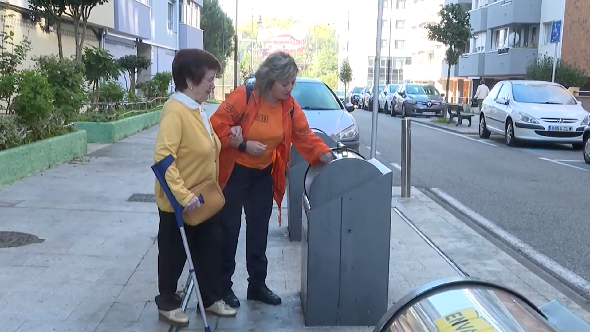 Mujer mayor acompañada de su cuidadora a tirar la basura. Mujer mayor acompañada de su cuidadora a tirar la basura.