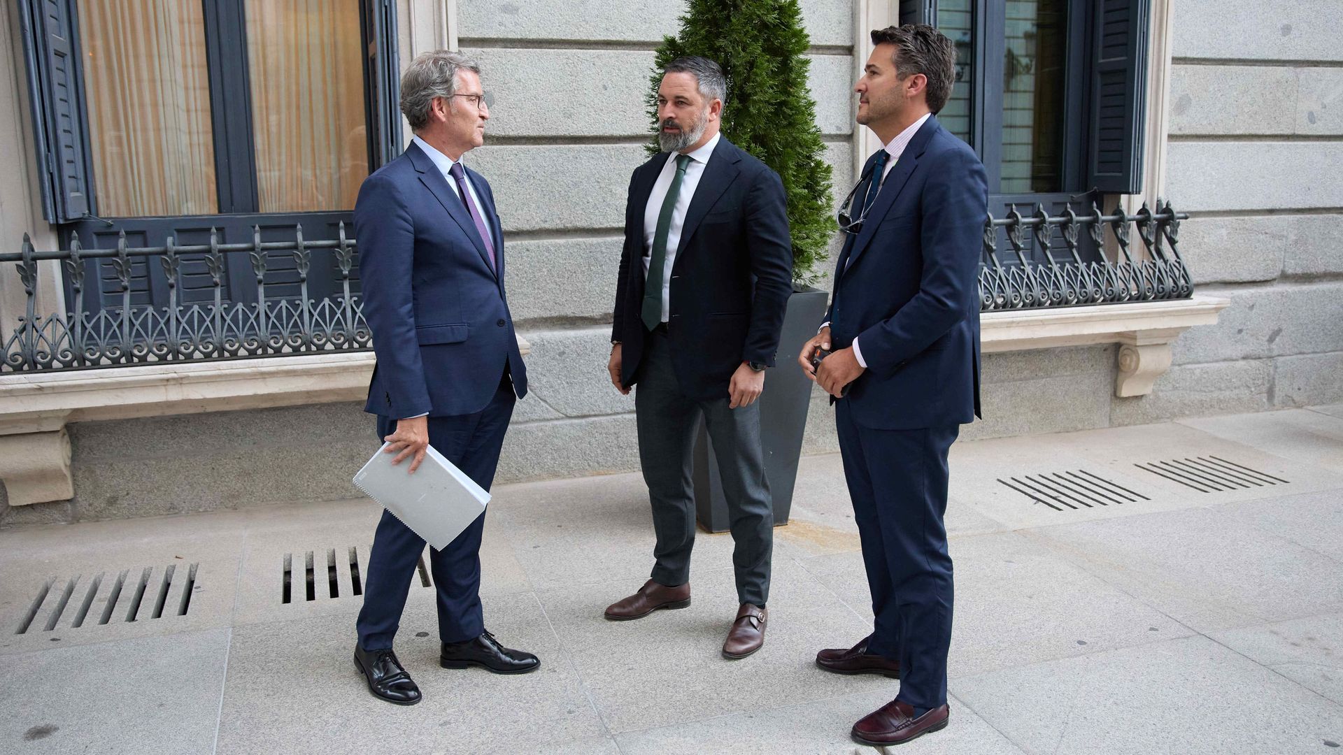 El presidente del PP, Alberto Núñez Feijóo (i) conversa con el presidente de VOX, Santiago Abascal (c), a su salida de una sesión plenaria en la Cámara Baja,