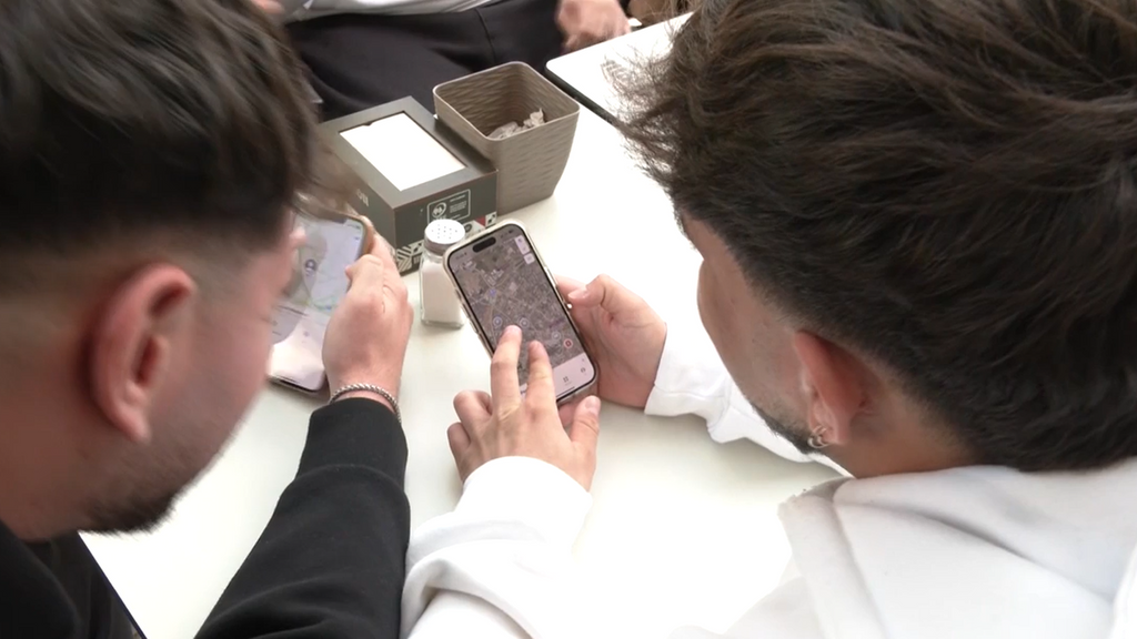 Jóvenes mirando las ubicaciones de sus amigos en el móvil.