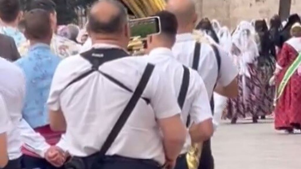 Un músico ve el Valencia CF mientras pasa por la Ofrenda 2024