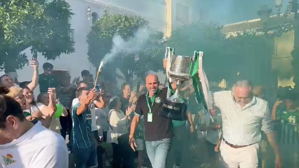Gordillo y el presidente de la Peña betica de Olivares llegan con la Copa entre bengalas
