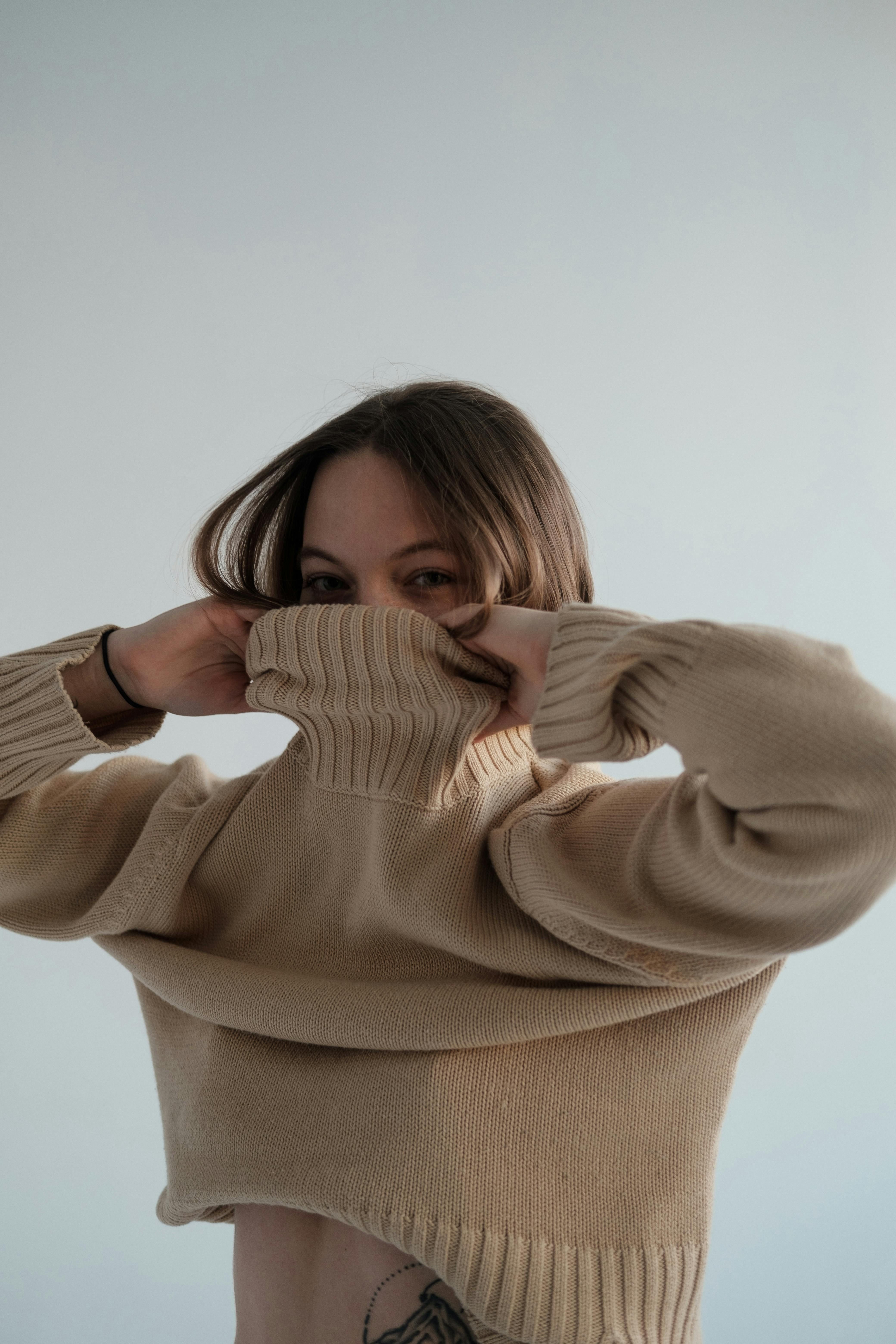 Mujer intentando ponerse un jersey de lana