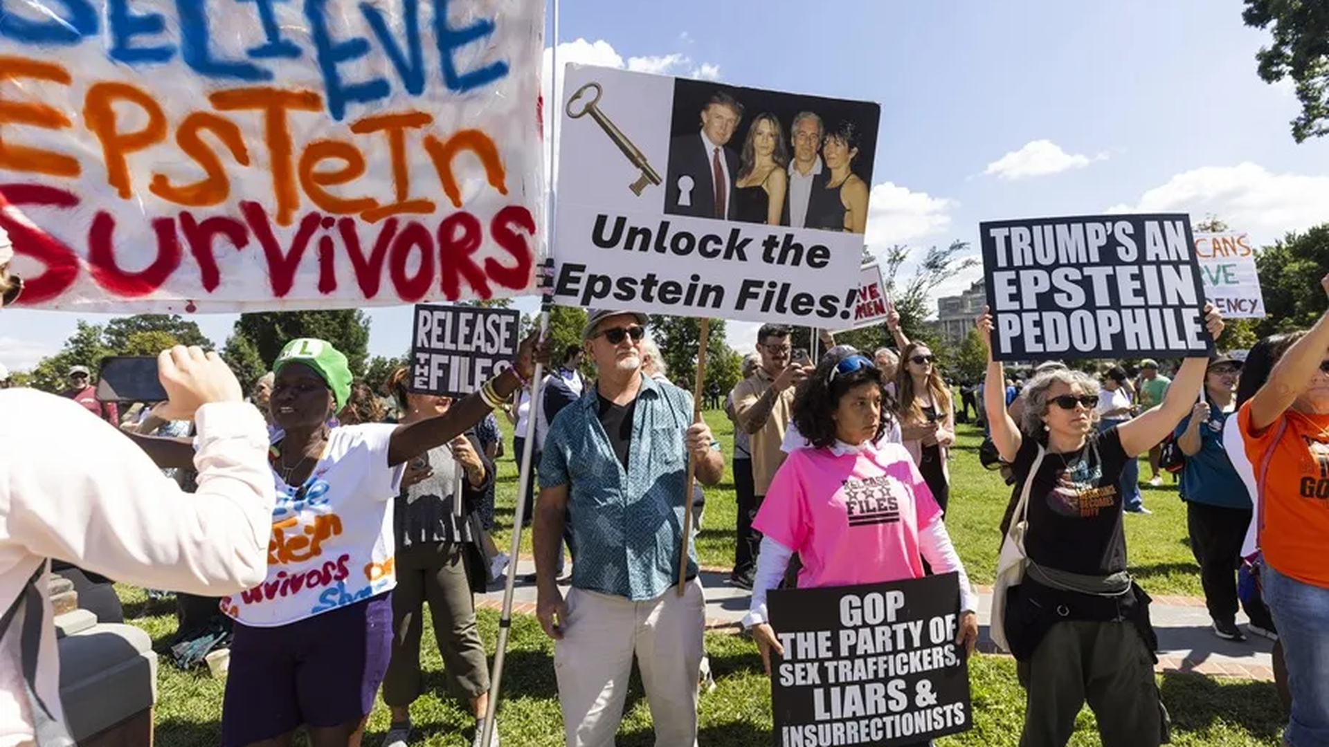 personas que apoyan a las víctimas de Jeffrey Epstein y muestran mensajes en contra de los supuestos vínculos con Donald Trump
