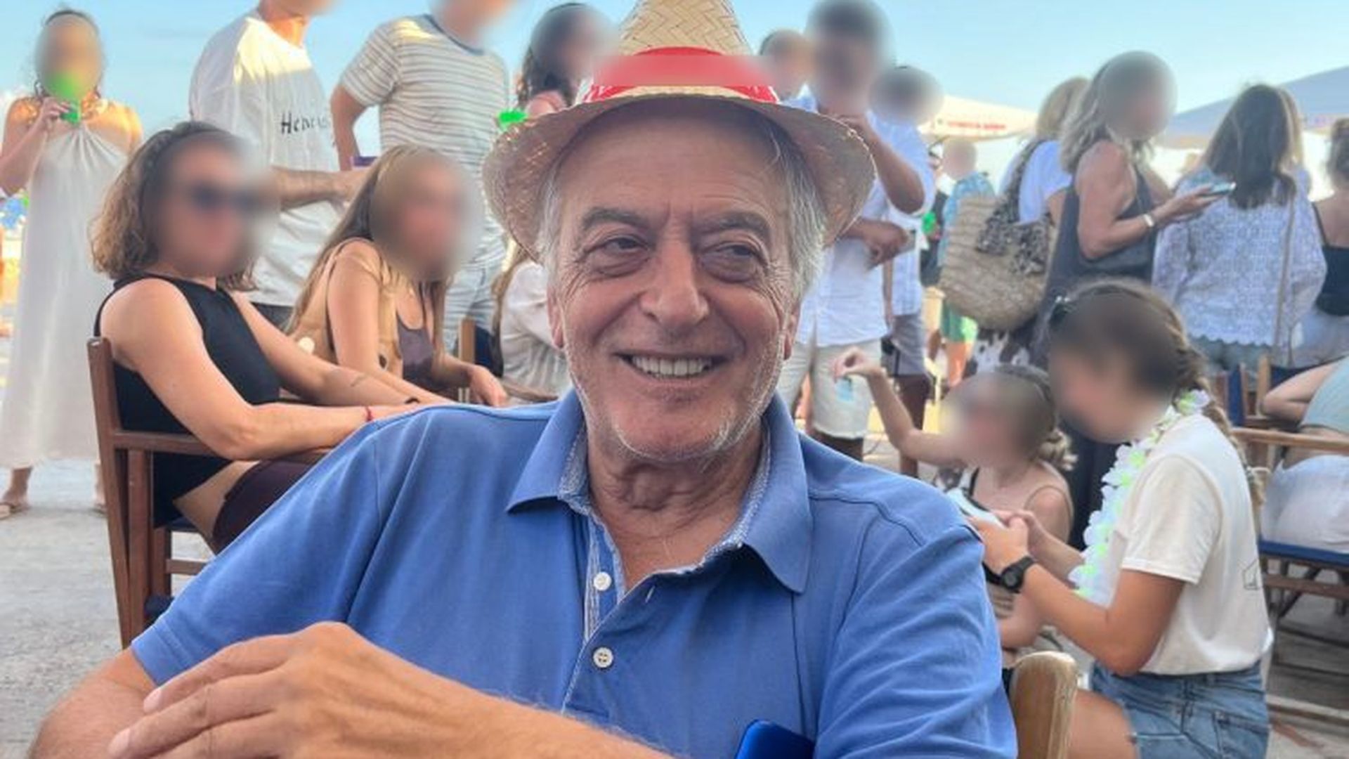 Un hombre delgado, de pelo corto canoso y ojos verdes