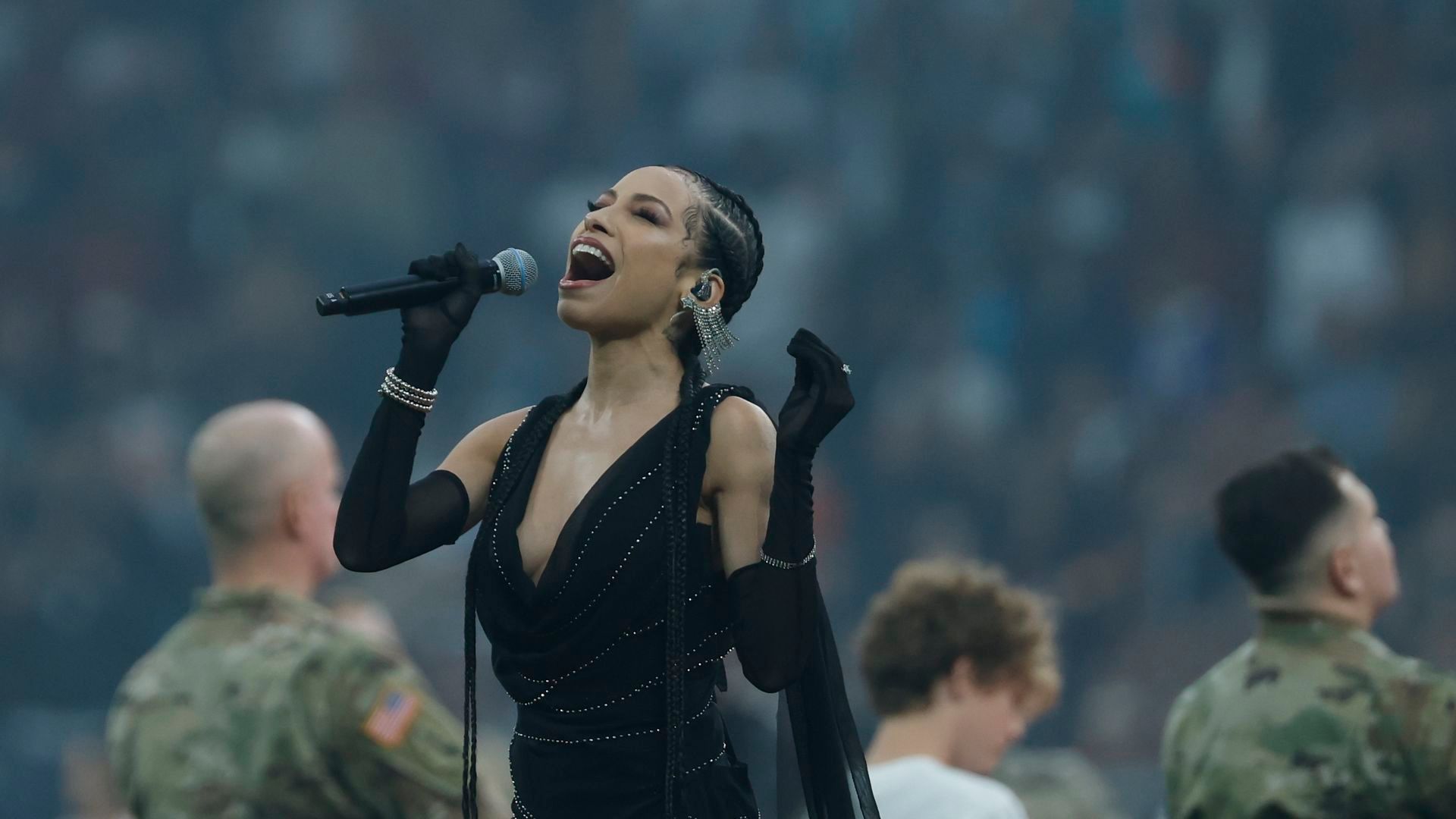 La cantante Karina Pasian canta el himno estadounidense durante el partido de liga regular de la NFL
