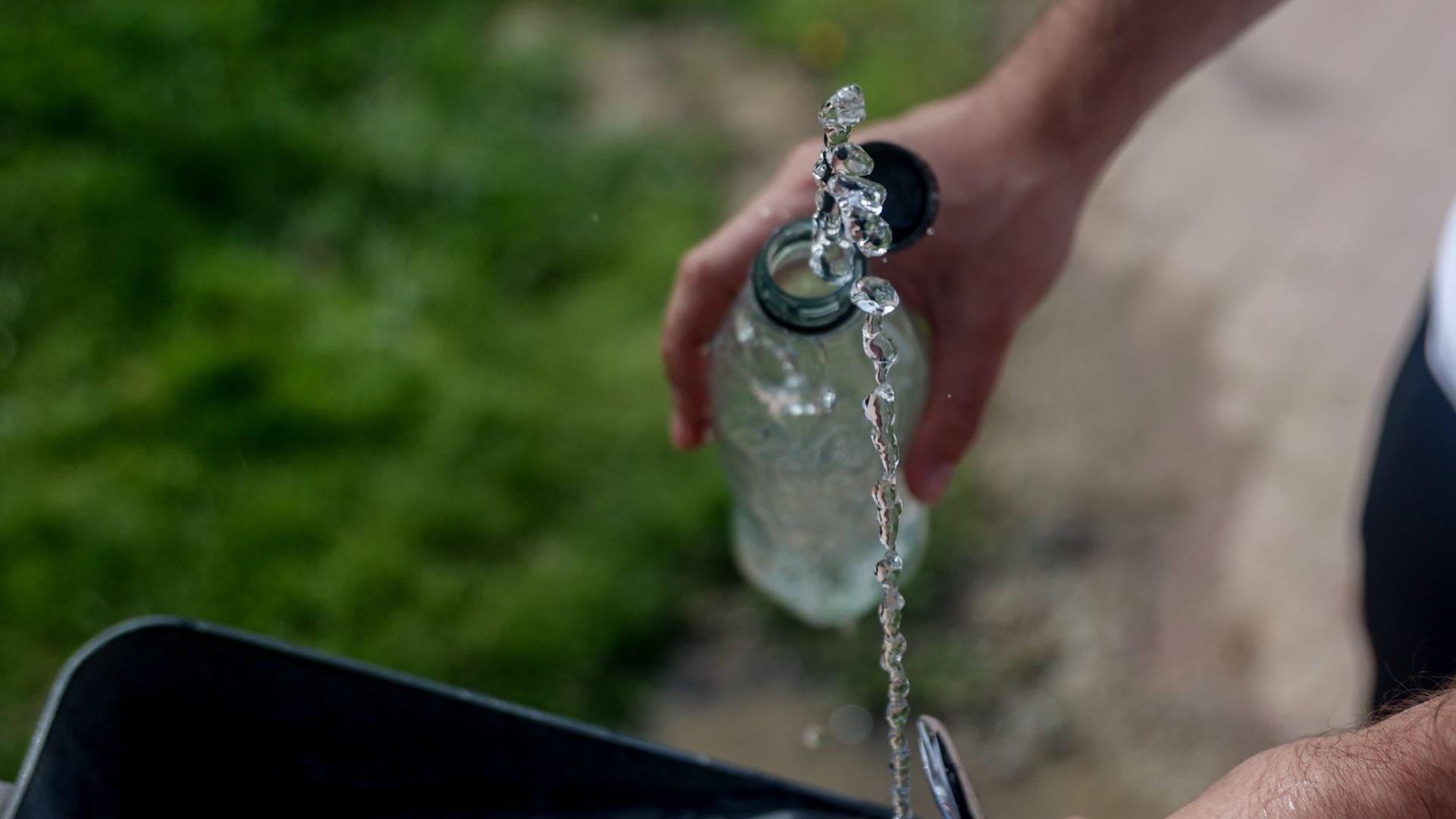 Imagen de archivo de una persona llenando una botella agua en una fuente