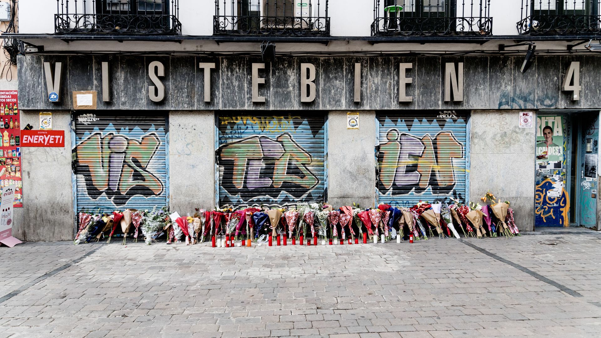 Flores y velas para homenajear a Conchi, la mujer de 61 años apuñalada en su comercio de la plaza Tirso de Molina, Madrid