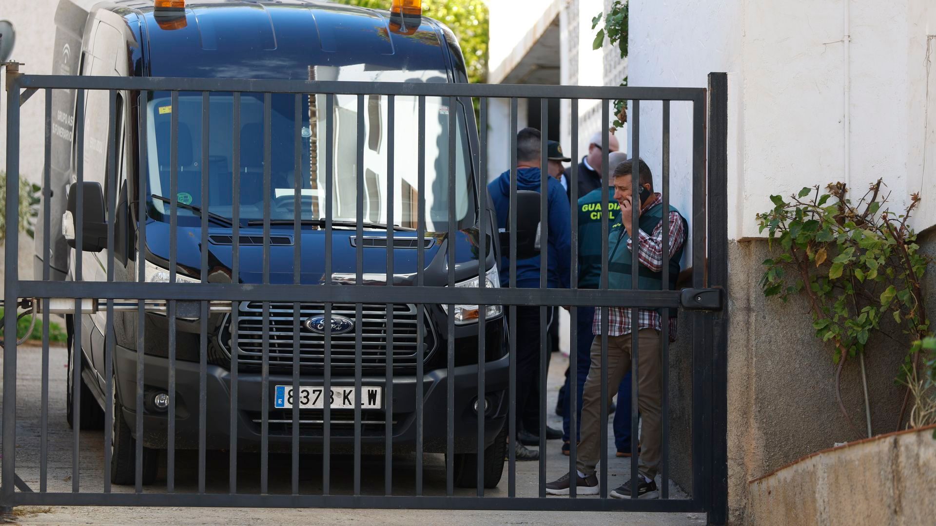 Un coche de servicio funerario espera el traslado del cuerpo de la mujer fallecida