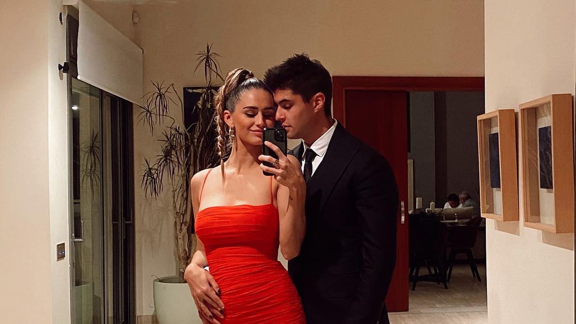 Javier Tudela y Marina Romero en el recibor mostrando el salón por su espejo