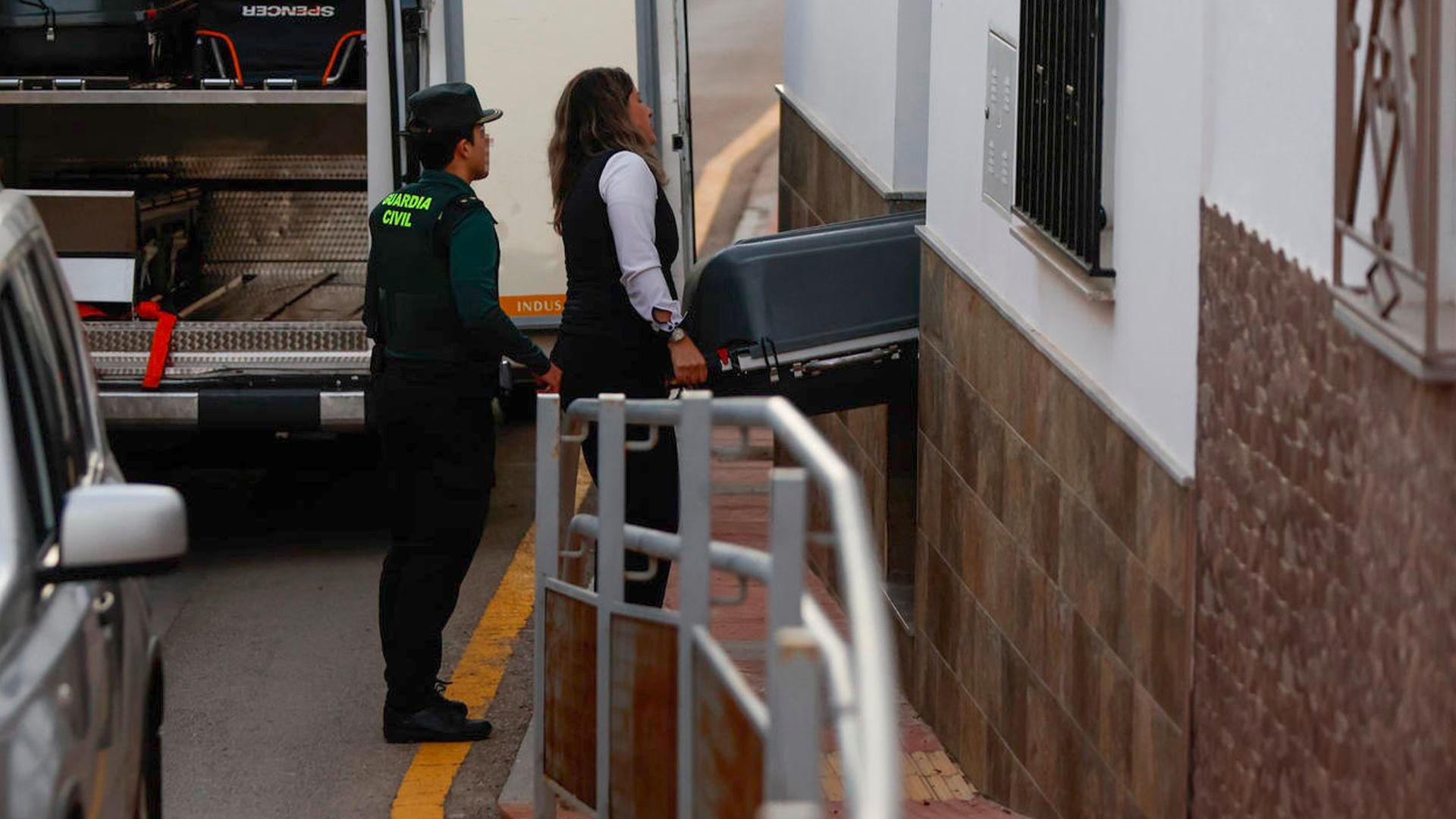 Trabajadores de los servicios funerarios retiran el cuerpo de una mujer de 25 años en Campillos, Málaga