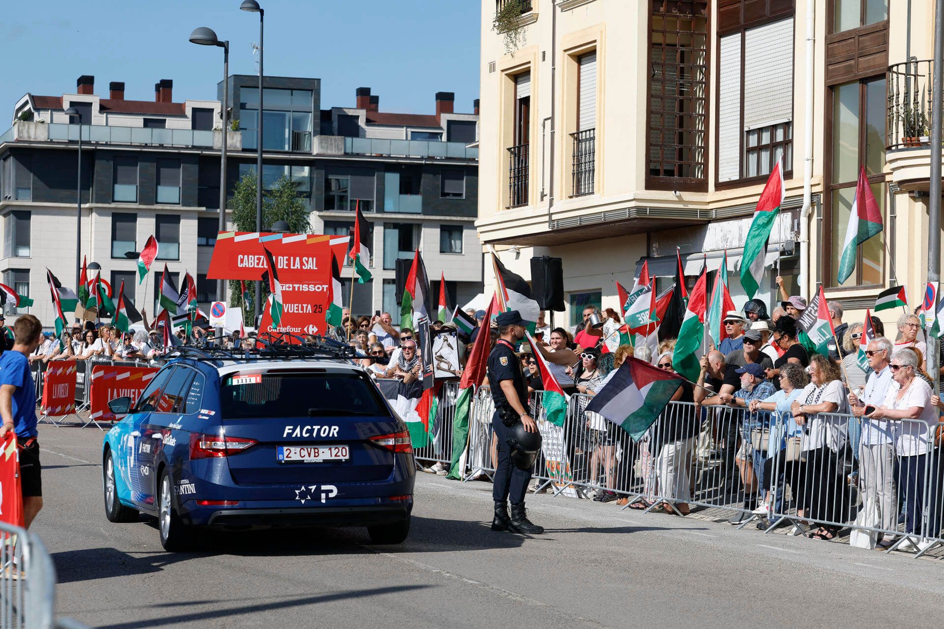  El coche del equipo Israel Tech pasa junto a manifestantes de apoyo a Palestina (FOTO: EFE).