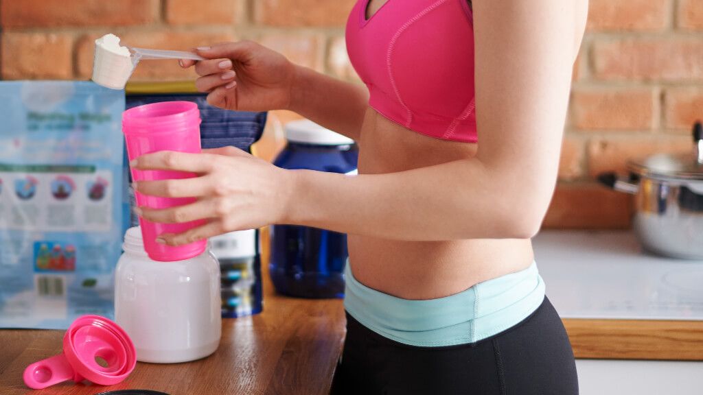  Mujer con ropa deportiva preparándose un batido