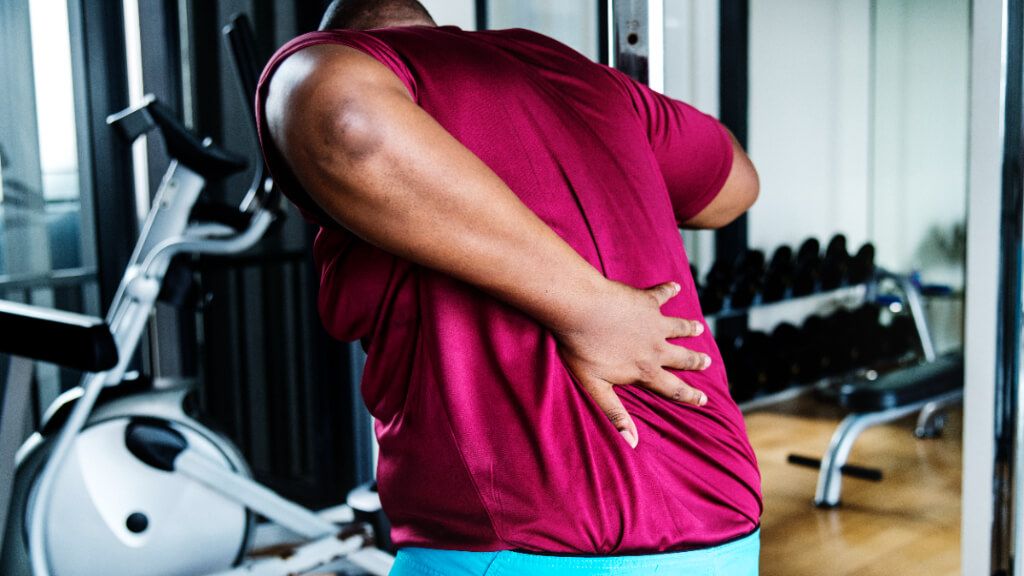  Hombre en el gimnasio con dolor de espalda