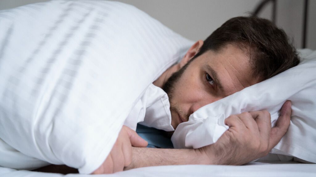  Hombre ansioso acostado en la cama